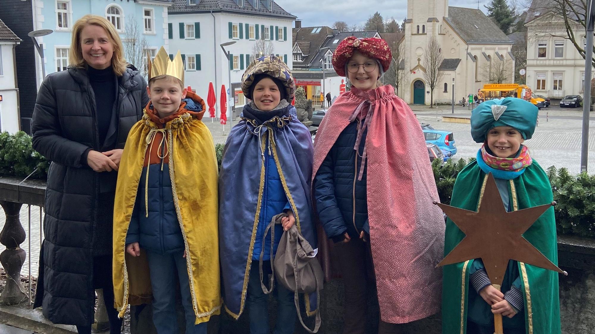 Eine Gruppe Sternsinger steht vor dem Wipperfürther Rathaus. Neben ihnen steht Bürgermeisterin Anne Loth.
