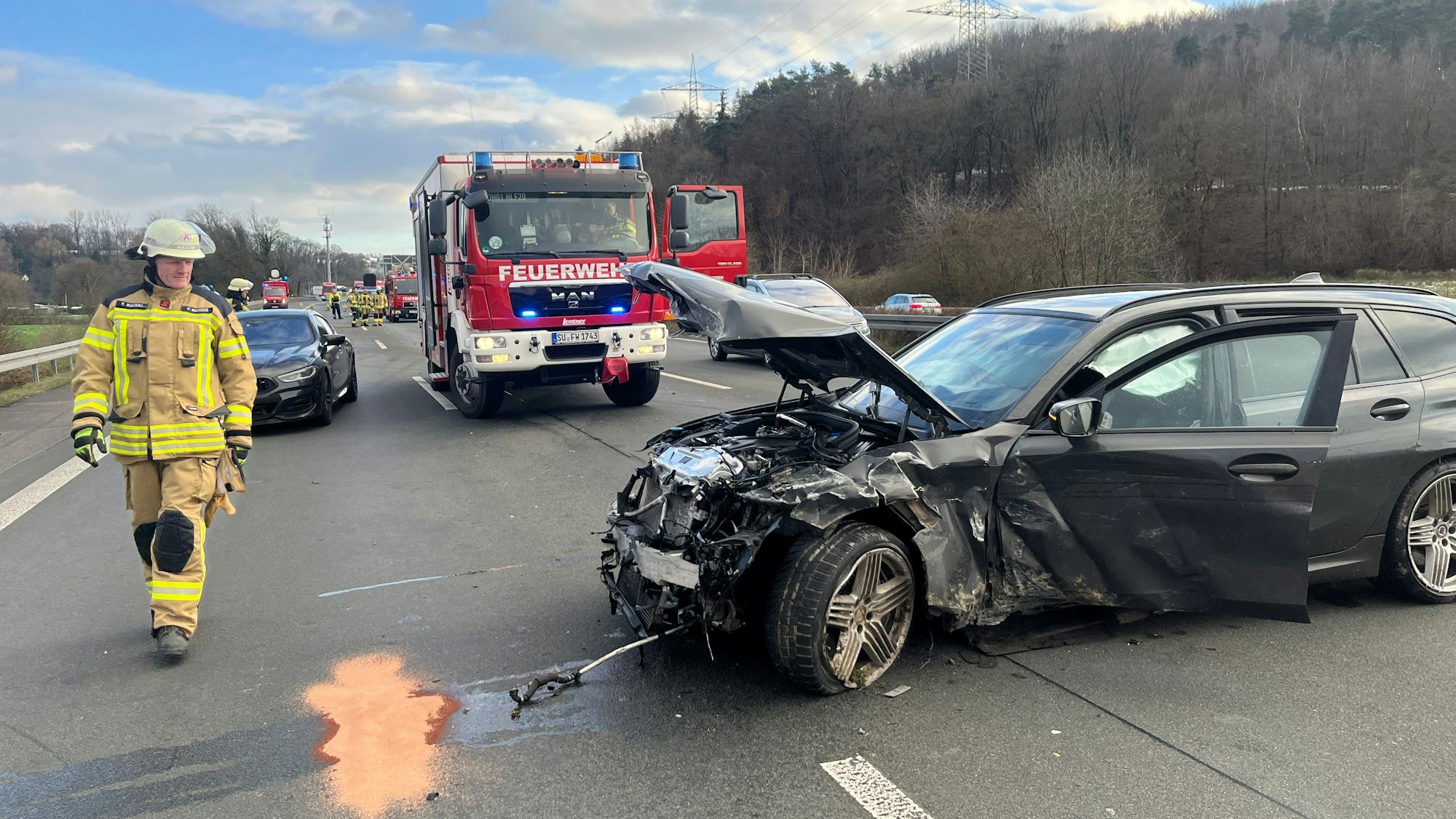 Ein schwer beschädigtes Auto steht quer zur Fahrtrichtung auf der Autobahn.