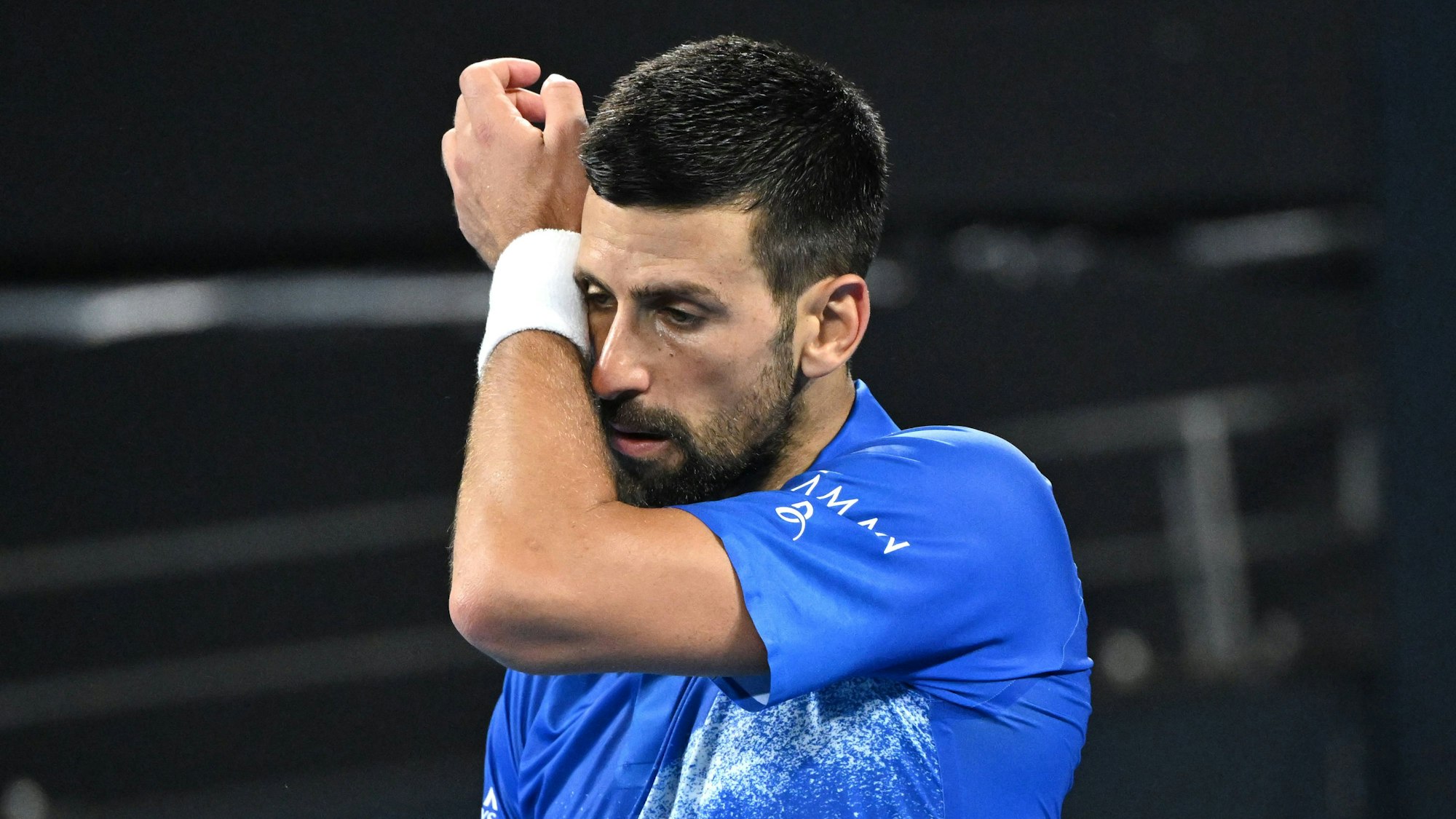 Novak Djokovic putzt sich den Schweiß ab.