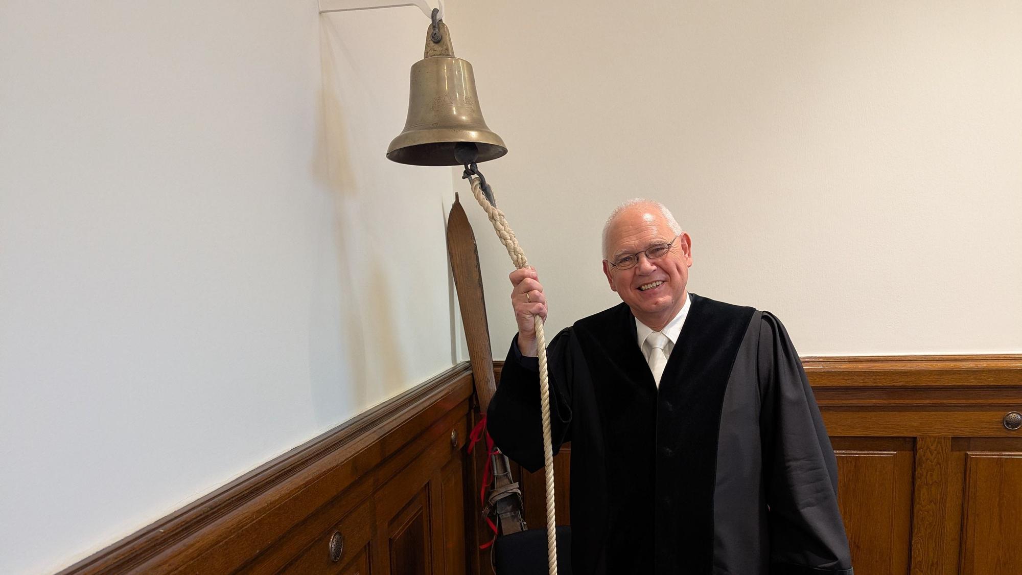 Richter Klaus Berghaus läutet die Glocke zu seinem letzten Prozess.
