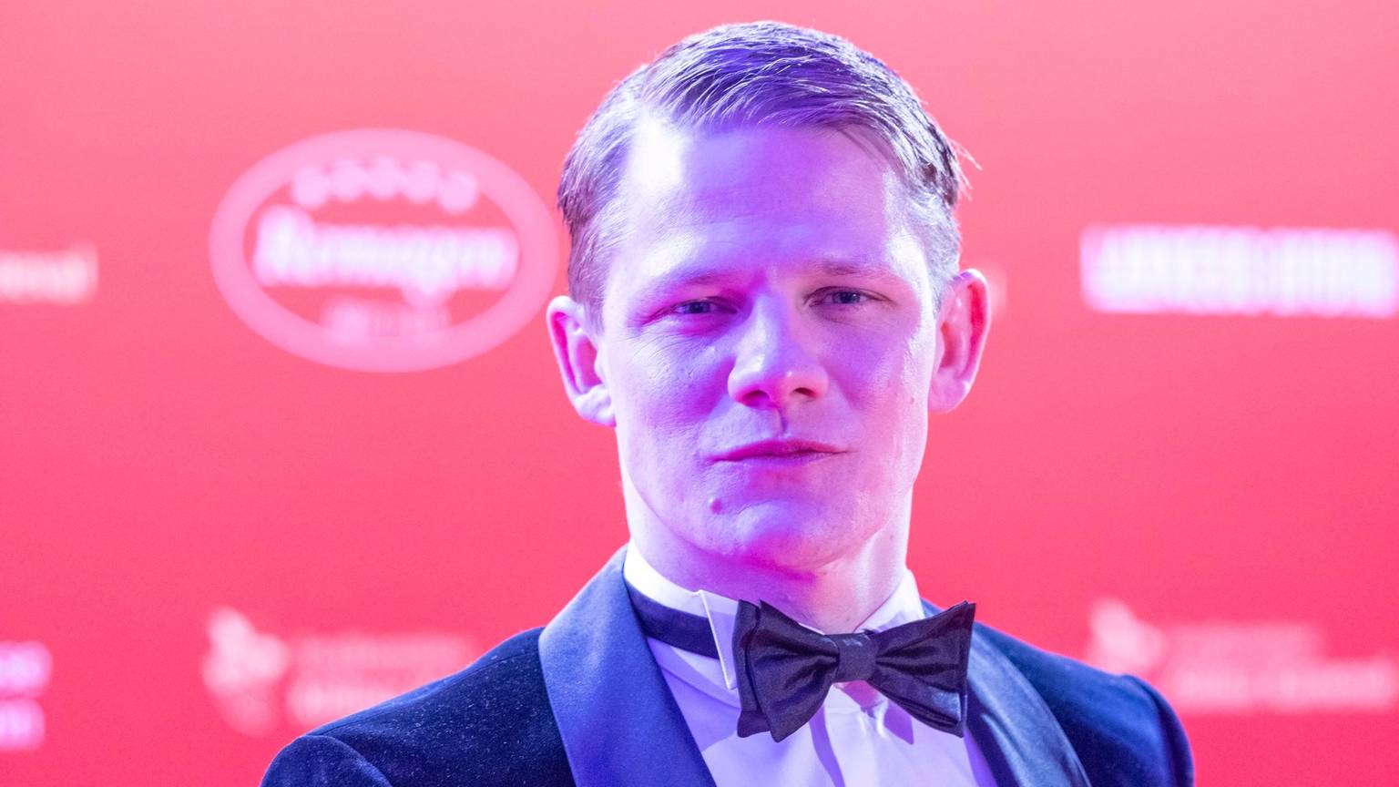 Schauspieler Max von der Groeben steht auf dem roten Teppich.