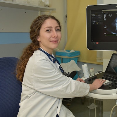 Zu sehen ist eine junge syrische Ärztin an einem medizinischen Apparat.