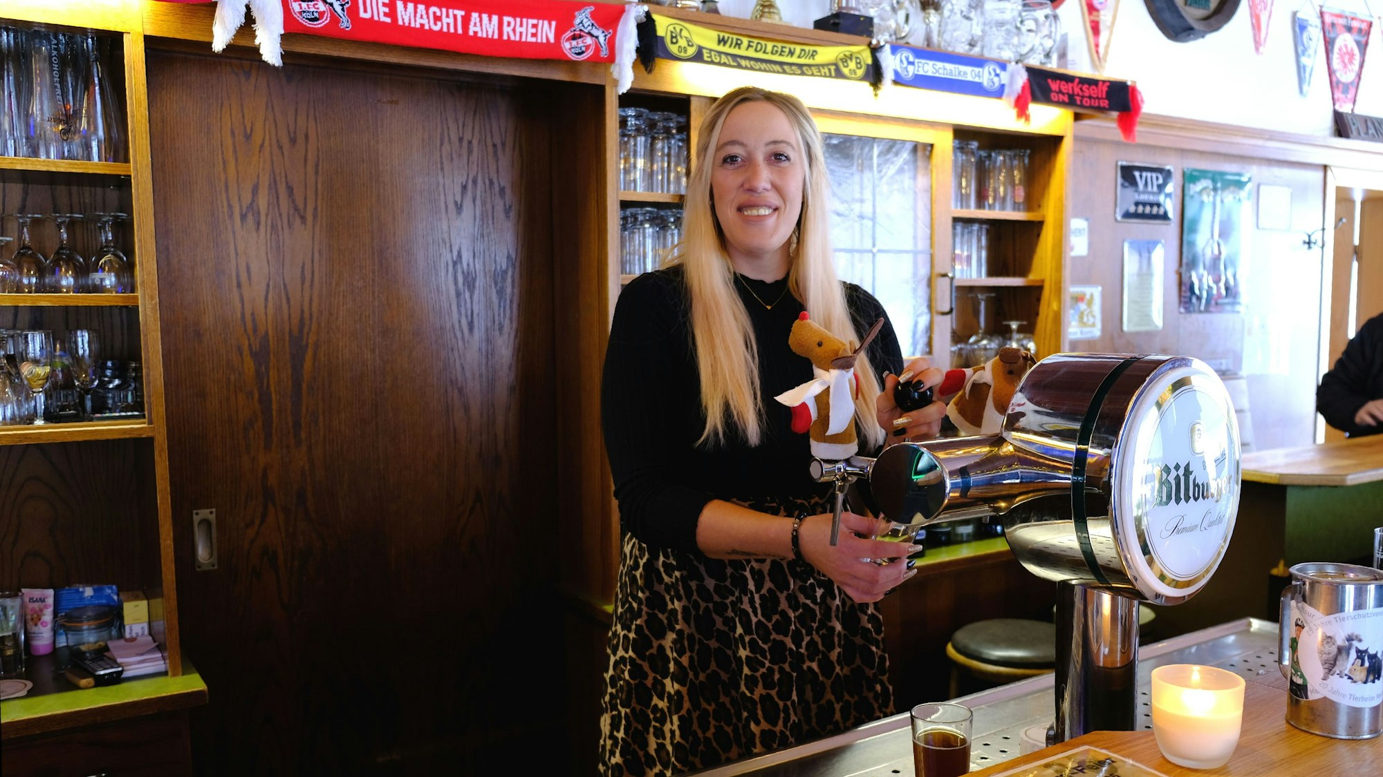 Wirtin Karina Hoffmann steht hinter der Theke der Puszta-Hütte in Mechernich und zapft ein Bier.