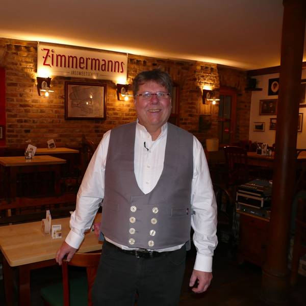 Ein Mann zapft Kölsch aus einem Fass.