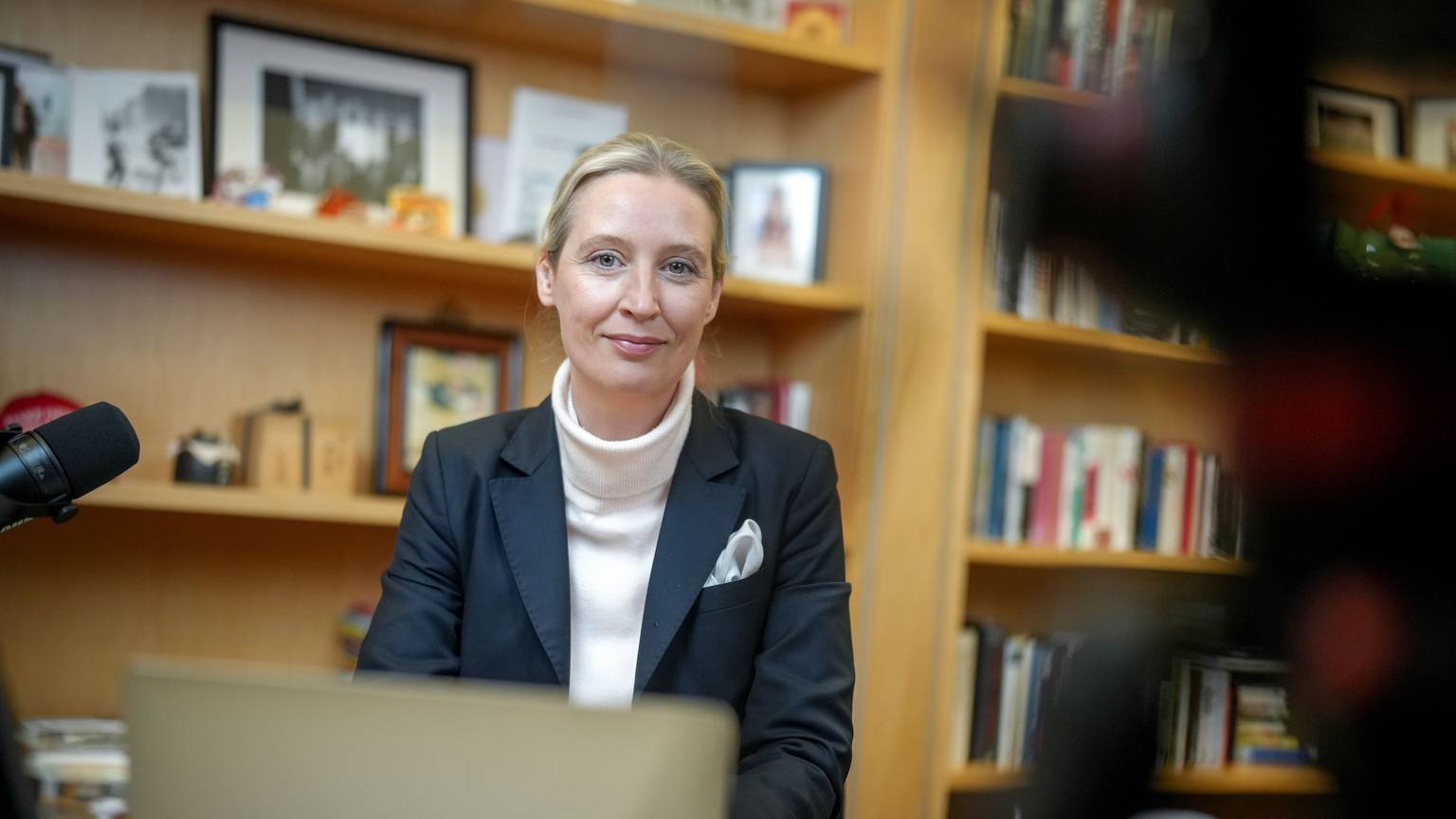 Alice Weidel, Fraktionsvorsitzende, Parteivorsitzende und Kanzlerkandidatin der AfD, sitzt vor dem Live-Talk mit dem US-Milliardär Elon Musk auf der Plattform X an Mikrofonen und einem Laptop in ihrem Büro des Jakob-Kaiser-Hauses.