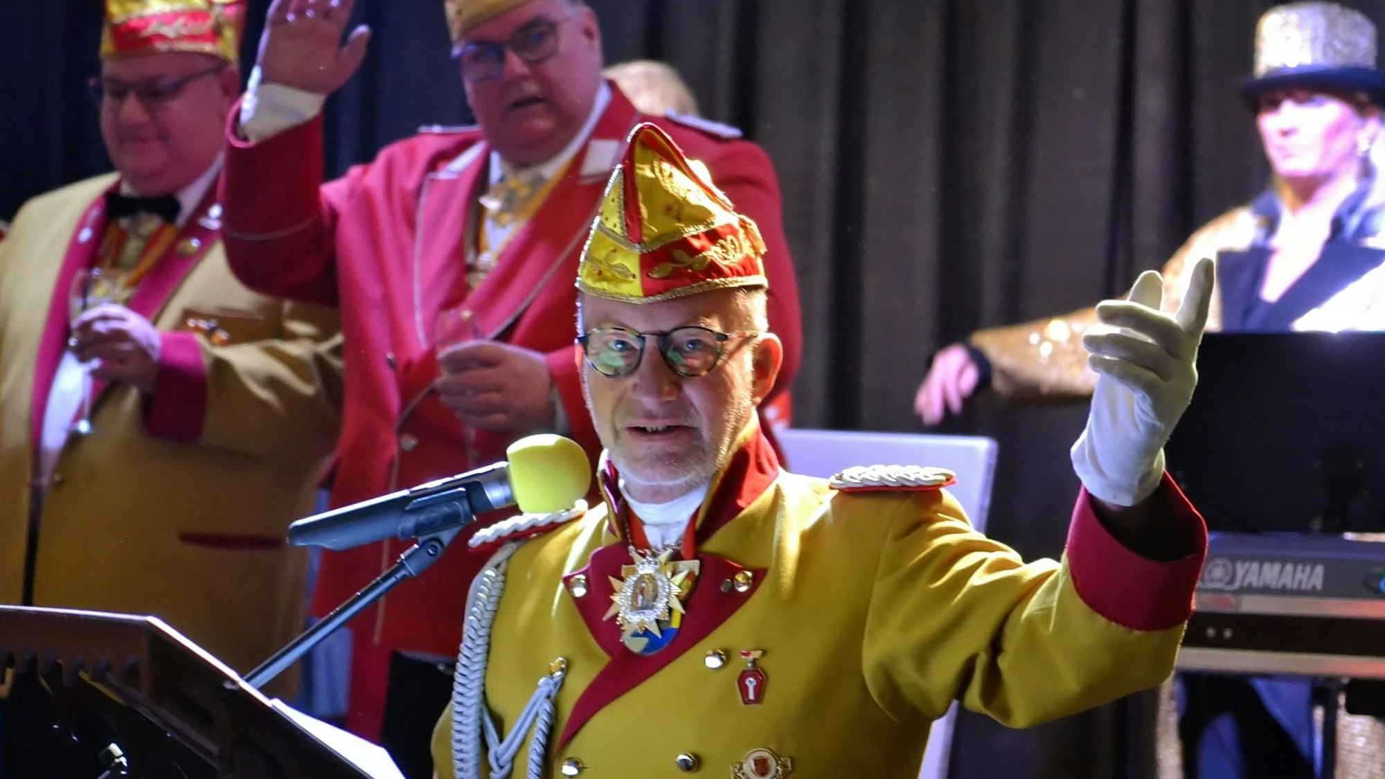 Michael Neugebauer steht in einer Karnevals-Uniform am Mikrofon.