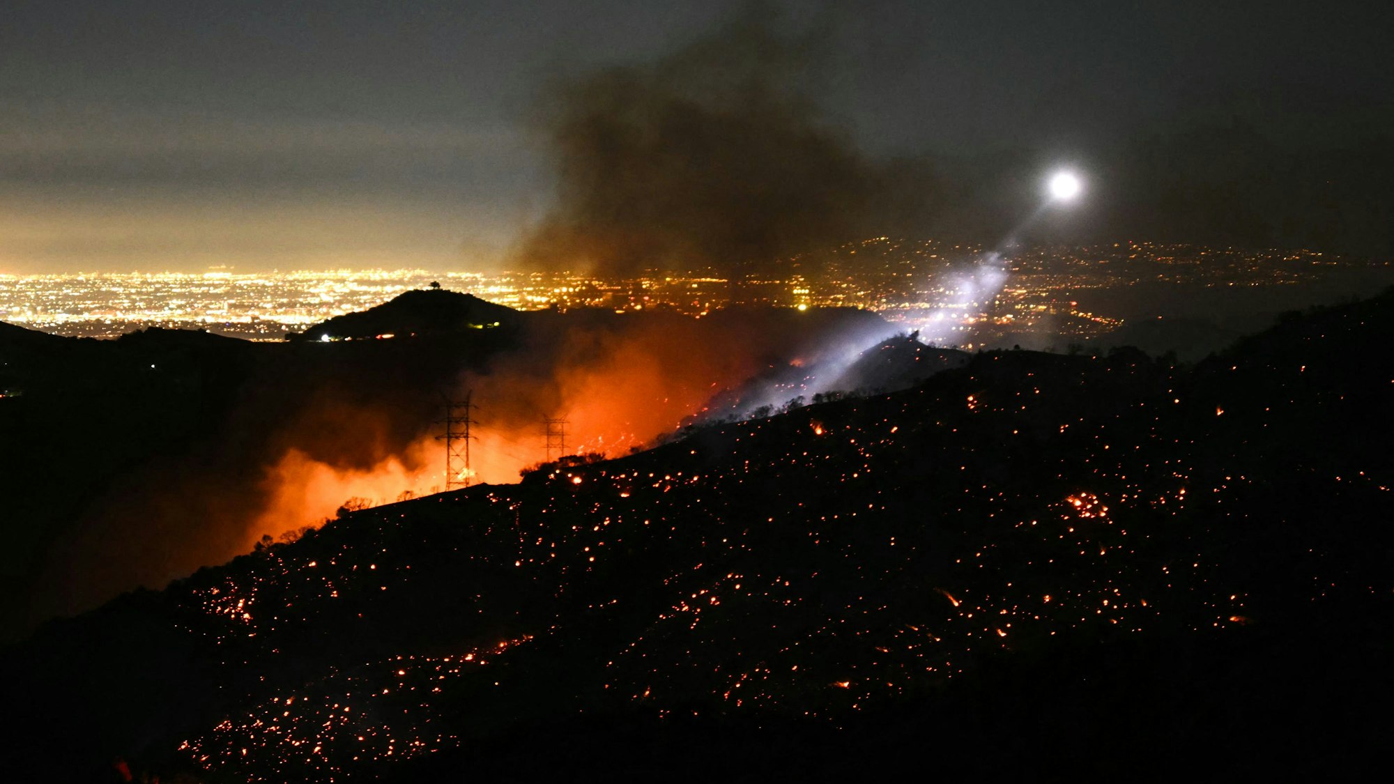 Das Licht eines Helikopters beleuchtet den Bereich der Palisades-Feuer in Los Angeles.