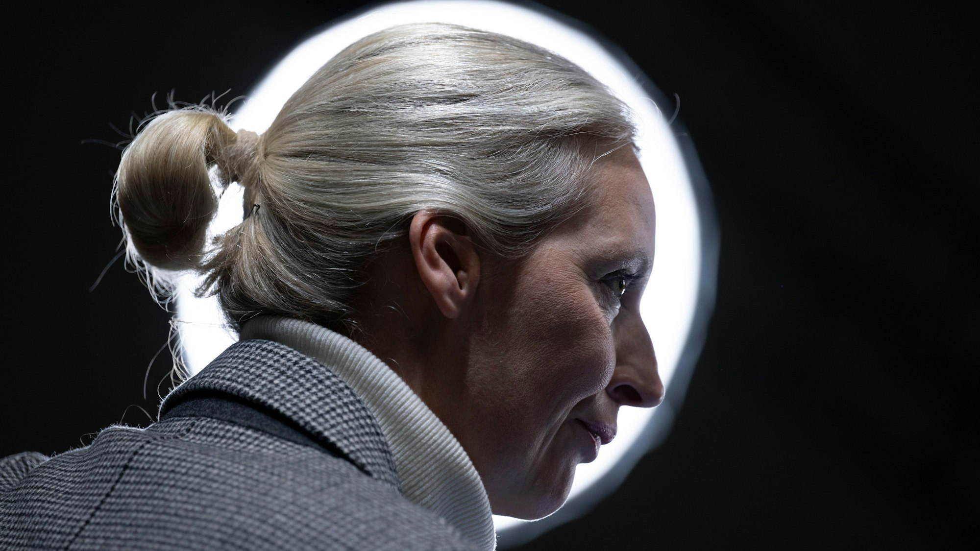 12.01.2025, Sachsen, Riesa: Alice Weidel, AfD-Bundesvorsitzende, wartet am Rande des Bundesparteitags ihrer Partei vor einem Scheinwerfer auf den Beginn eines TV-Interview. In Riesa will die AfD ihr Wahlprogramm beschließen. Foto: Sebastian Kahnert/dpa +++ dpa-Bildfunk +++