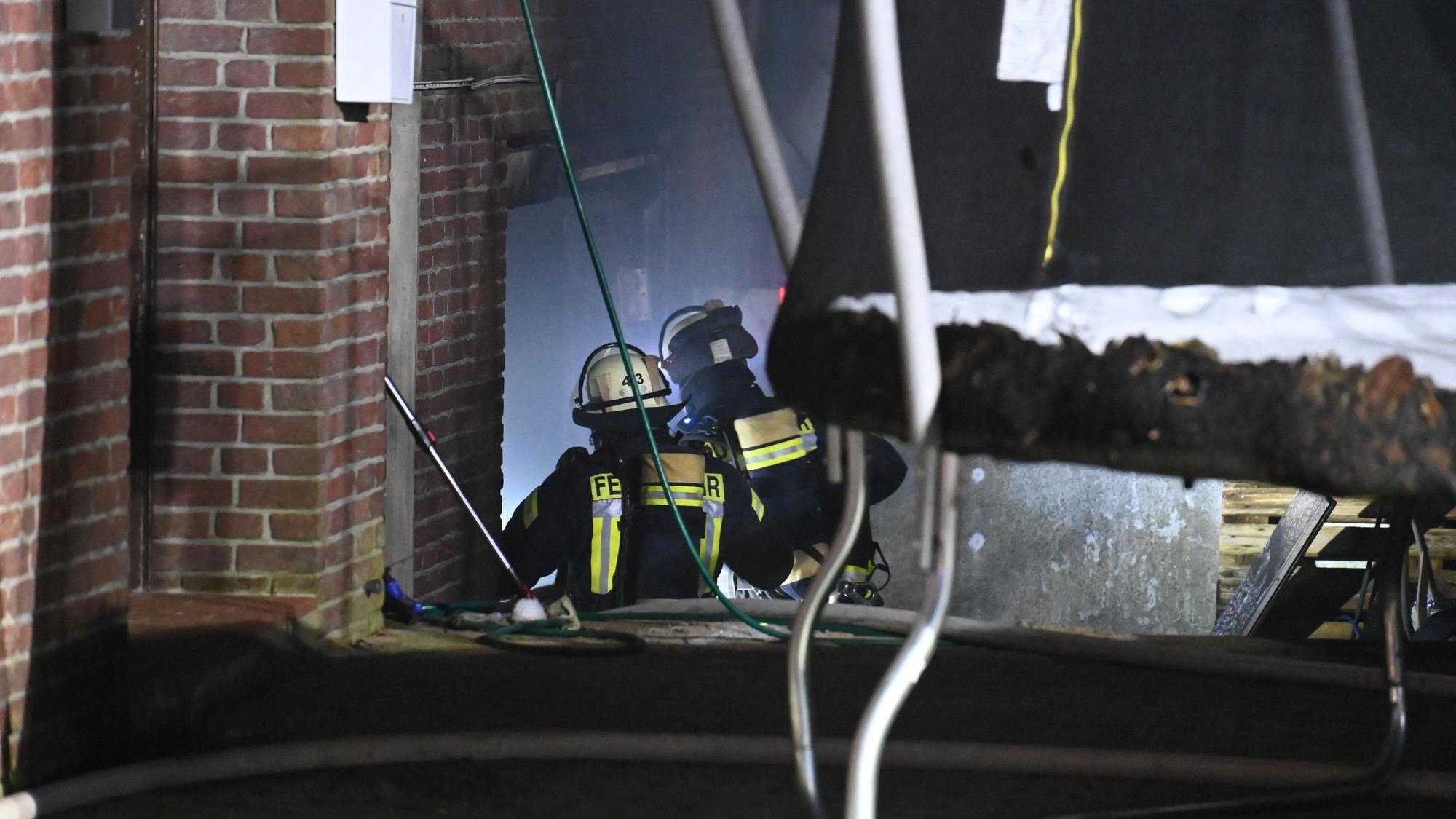 Feuerwehrleute betreten das Gebäude, nachdem sie es gelöscht hatten.