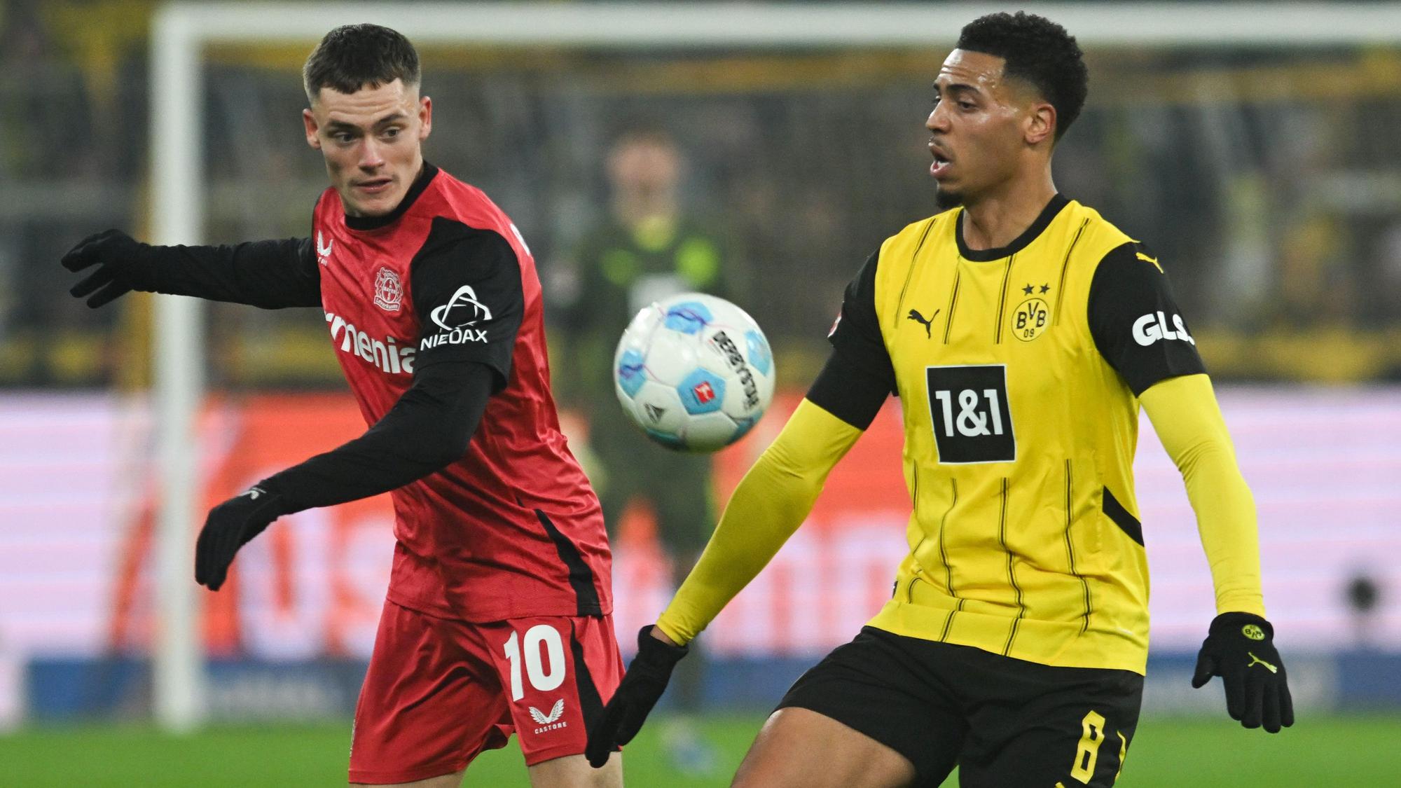 Dortmunds Felix Nmecha (r) und Leverkusens Florian Wirtz kämpfen um den Ball.