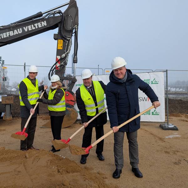 Das Foto zeigt die Vertreterinnen und Vertreter von Air Products und der Stadt mit Helm und Spaten auf der Baustelle.