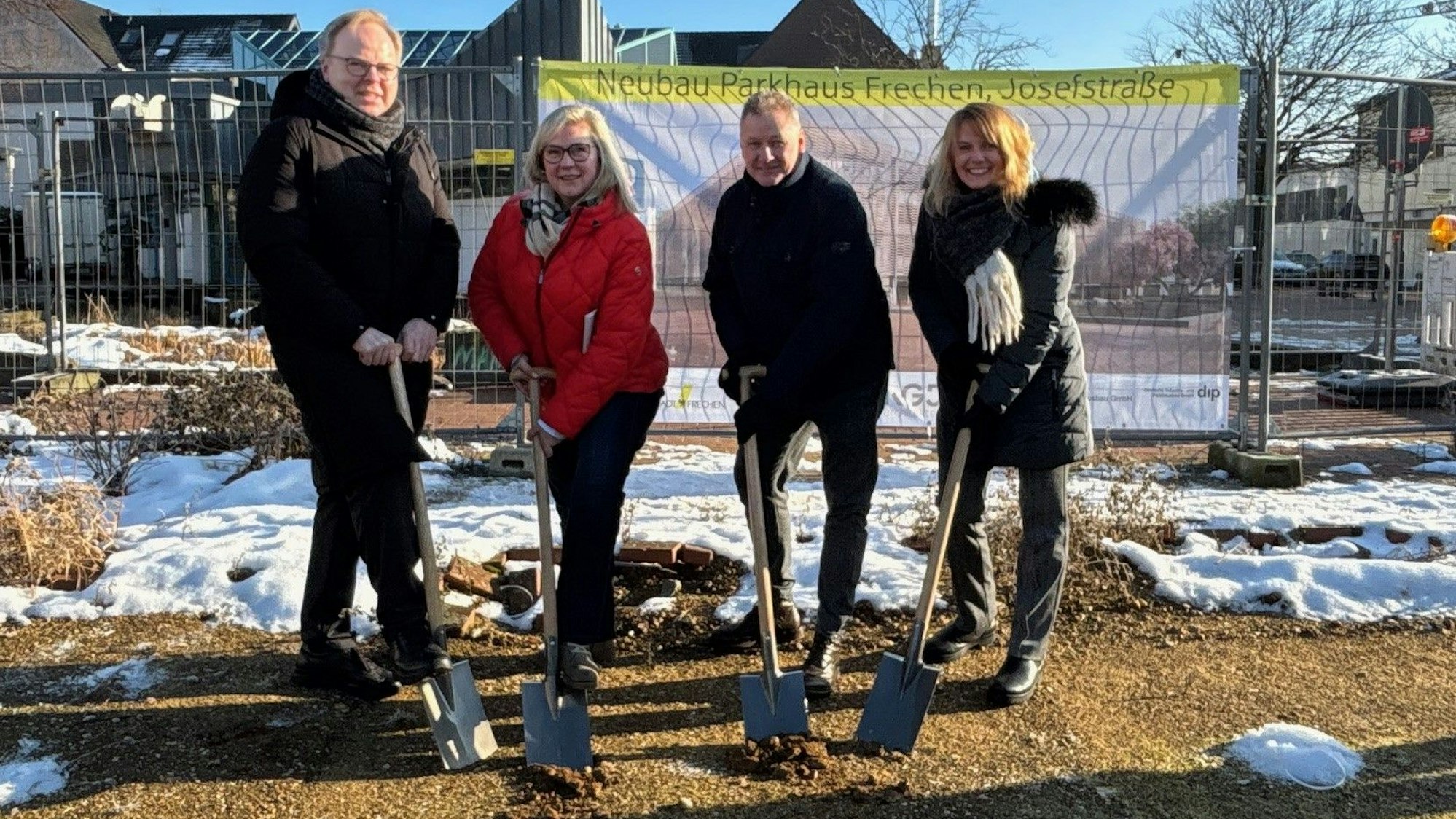 Auf dem Bild sind zwei Frauen und zwei Männer mit Spaten zu sehen, die symbolisch etwas Erde schaufeln.