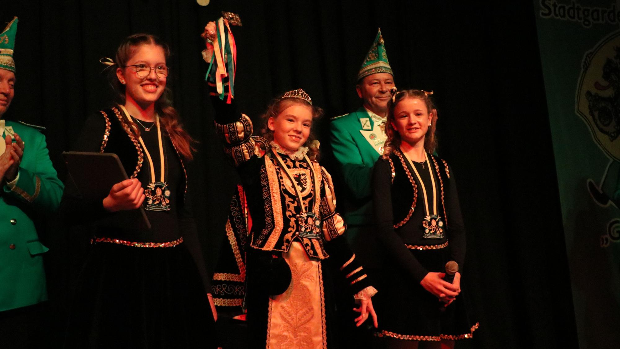 Auf dem Bild sind drei Mädchen auf einer Karnevalsbühne zu sehen.