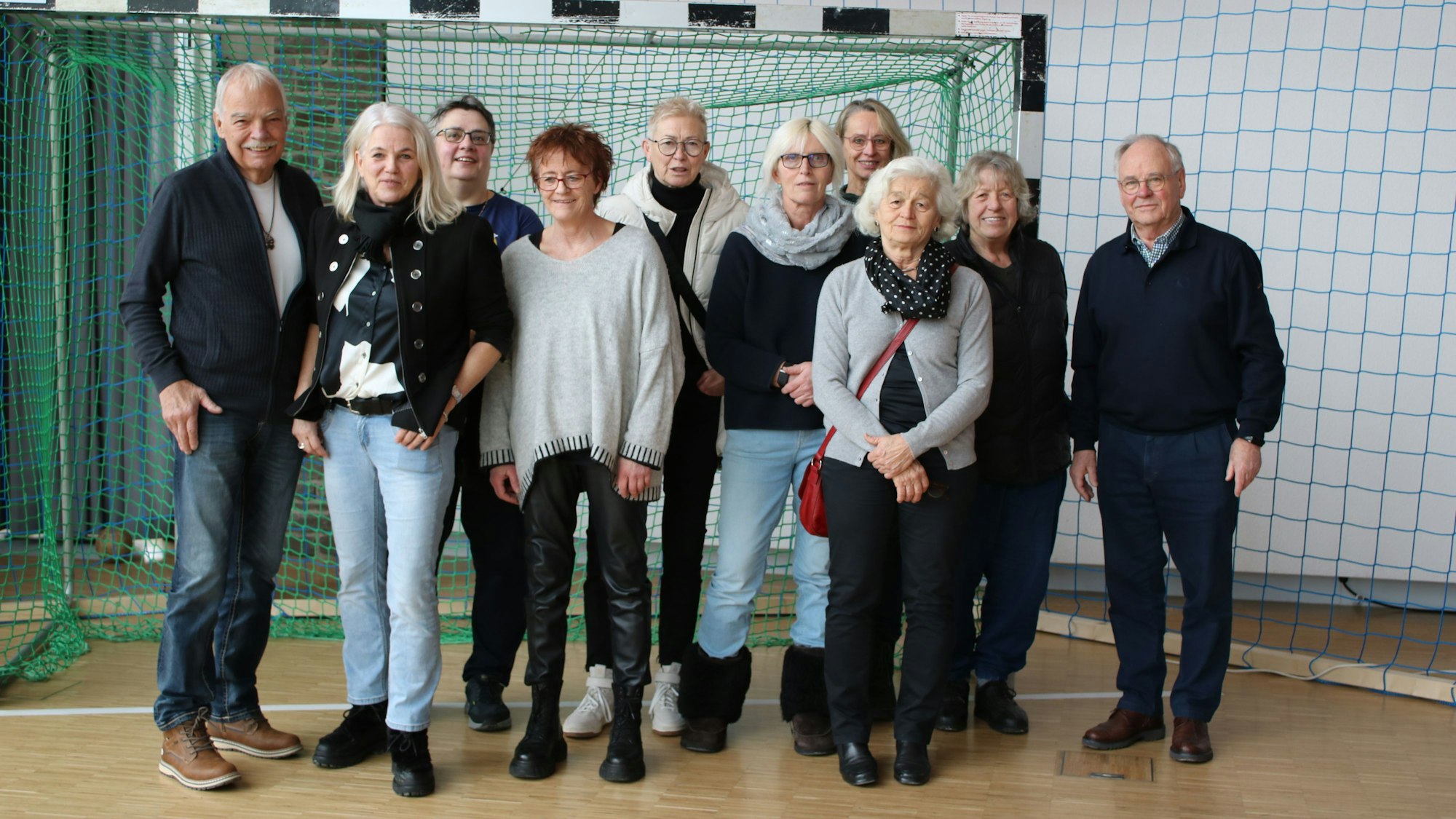 Gruppenfoto in einem Handballtor, v.l.: Physio Felix Zimmermann, Dagmar Wigger, Hille Schönauer, Susi Fabritius, Rita Bockemühl, Patricia Seifert, Ute Longerich, Monika Döring und Rolf Egbert.