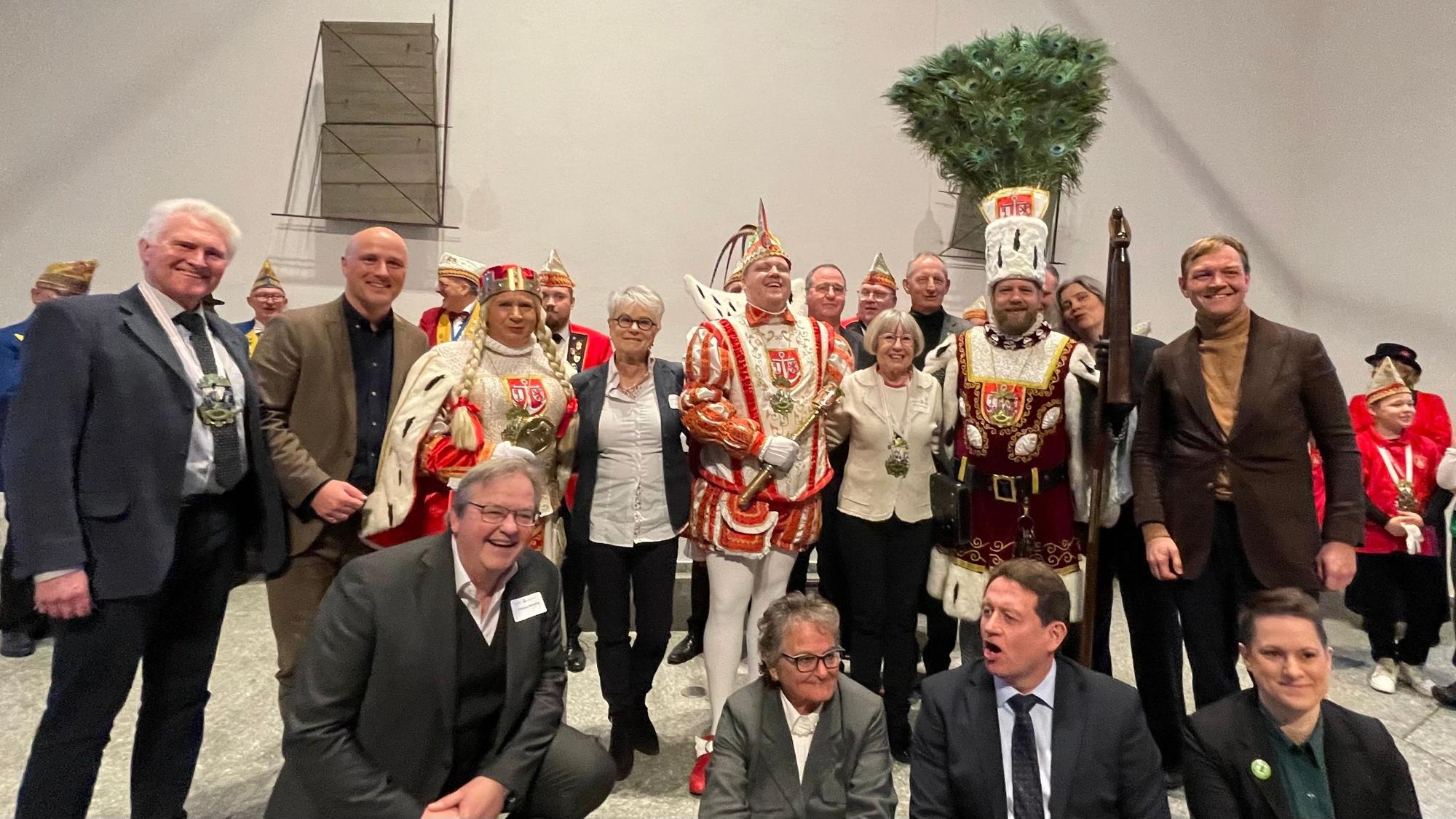 Gruppe von Menschen mit dem Rodenkirchener Dreigestirn. Obere Reihe von links Manfred Giesen (Die Grünen) Bezirksbürgermeister, Sven Lehmann (Die Grünen) Parlamentarischer Staatssekretär im Bundesfamilien Ministerium, Jungfrau Ulla, Iris Ebel-Philippi (Bürgervereinigung) Prinz Andy, Beatrix Polgar-Stüwe (Bürgervereinigung), Bauer Marcus. Vorne erster von links Wolfgang Behrendt (Vorsitzender Bürgervereinigung).