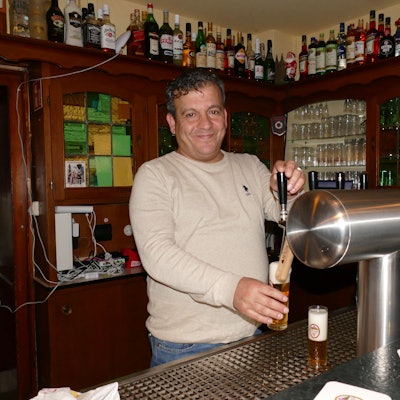 Ein Mann zapft Kölsch an einer Zapfanlage.