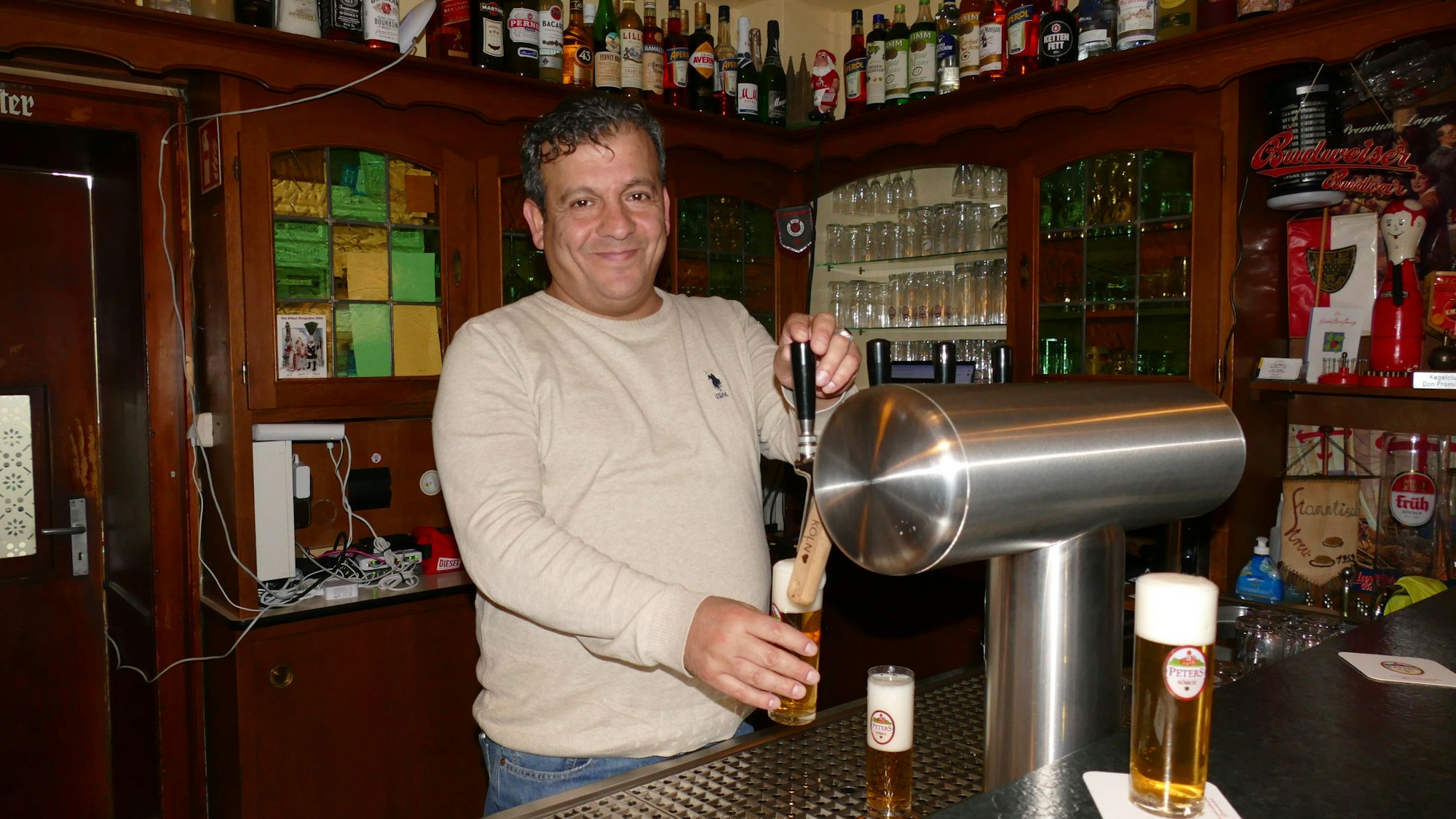 Ein Mann zapft Kölsch an einer Zapfanlage.