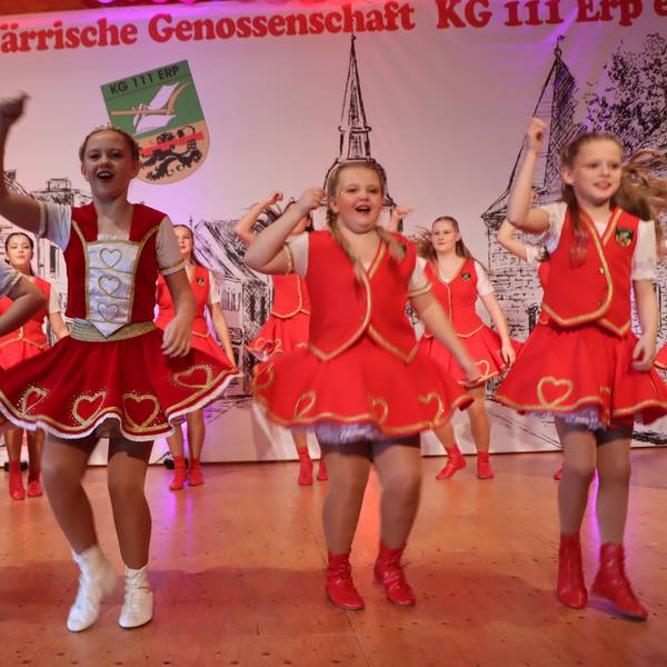 Mädchen in roten Kleidern tanzen auf einer Bühne.