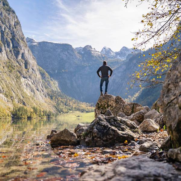 Mann steht auf einem Felsen in der Nähe des Obersees und der Berge in Berchtesgaden.