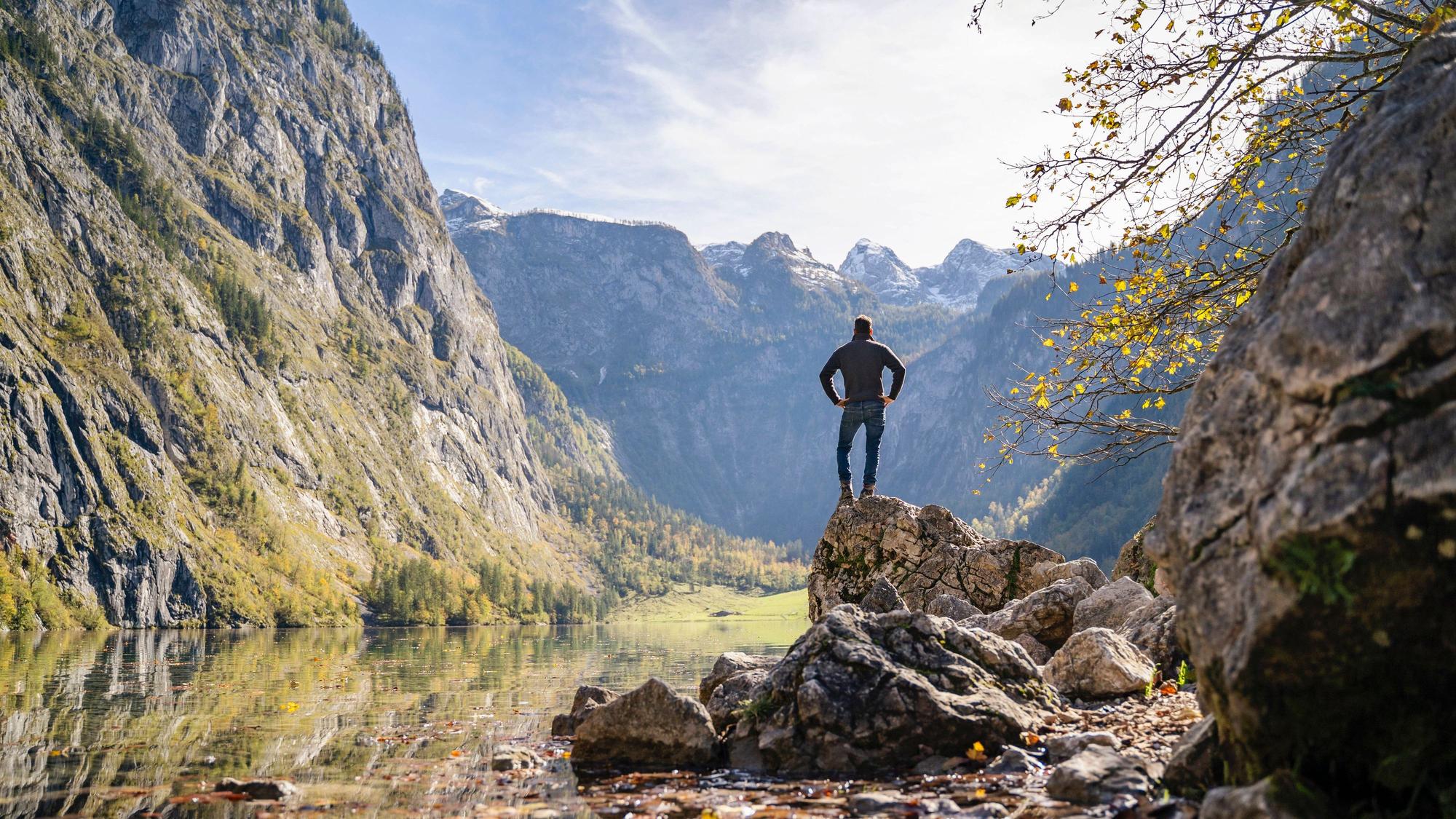 Mann steht auf einem Felsen in der Nähe des Obersees und der Berge in Berchtesgaden.