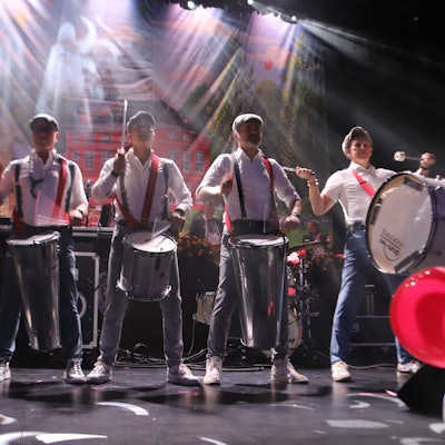 Fünf Musiker schlagen auf ihre Trommeln.