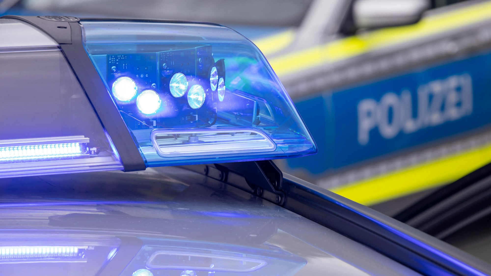 Zu sehen ist ein Blaulicht auf dem Dach eines Polizeifahrzeugs.