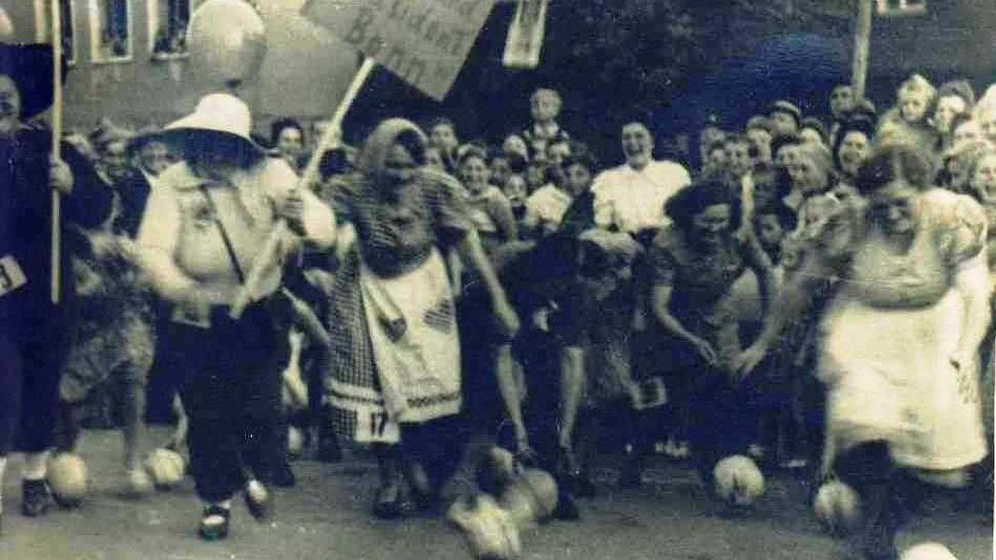 Auf einem Schwarz-Weiß-Bild jagen viele Frauen den Kohlköpfen nach.