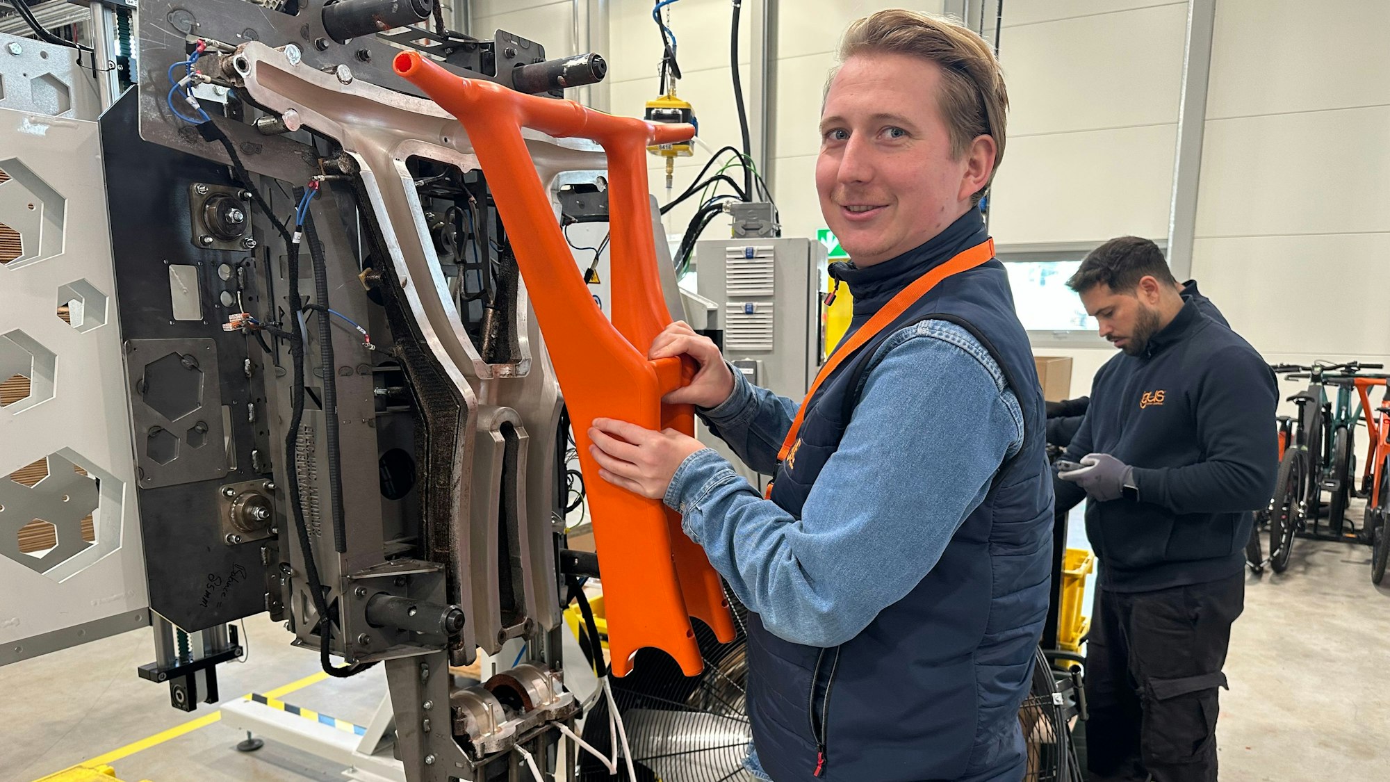 Igus-Fahrradprojektleiter Sven Terhardt  zeigt, wo die Kunststoffteile produziert werden.