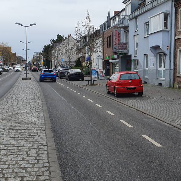Das Foto zeigt eine Straße mit einem Schild, welches das Überholen von Zweirädern verbietet.