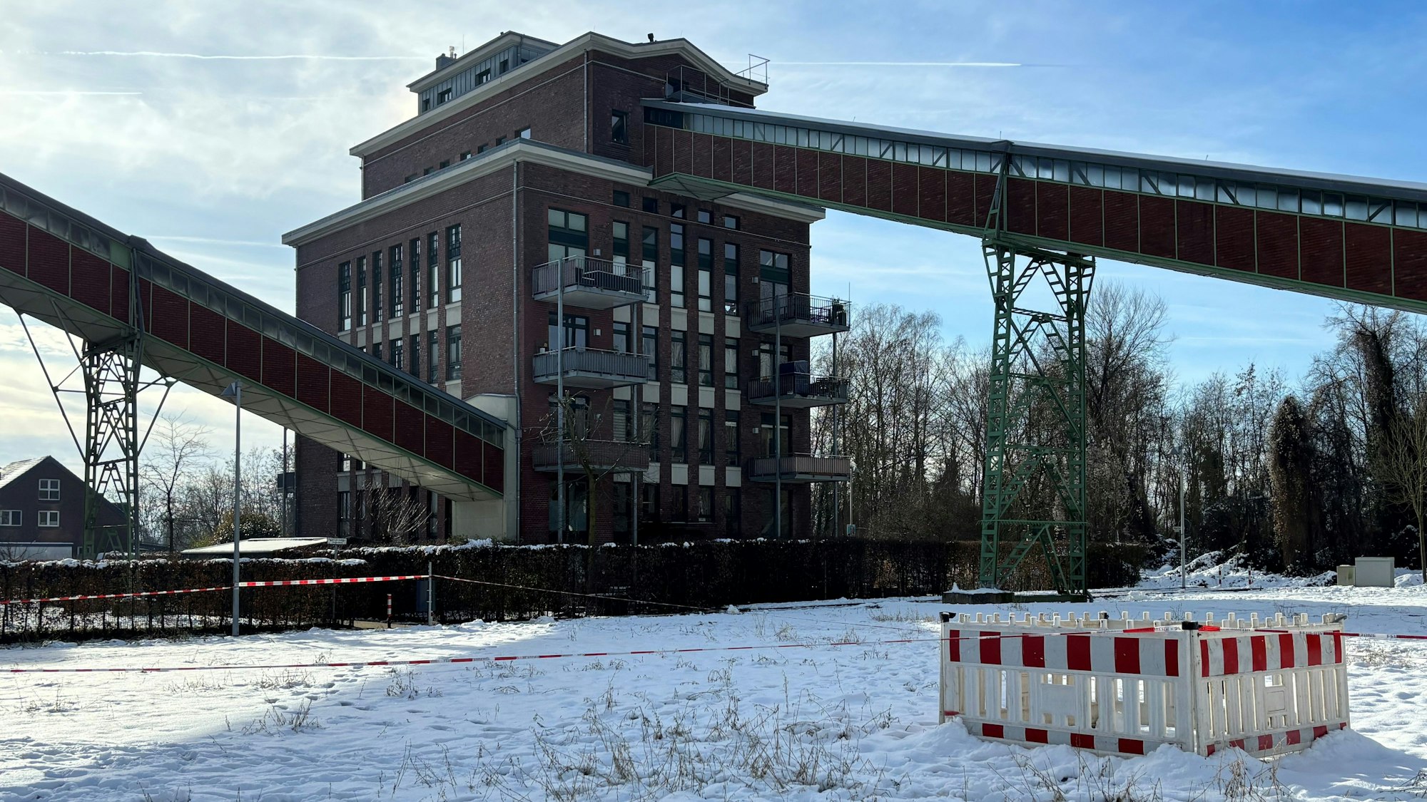 Auf dem Bild sind ein altes Fabrikgelände und ein Absperrgitter zu sehen.