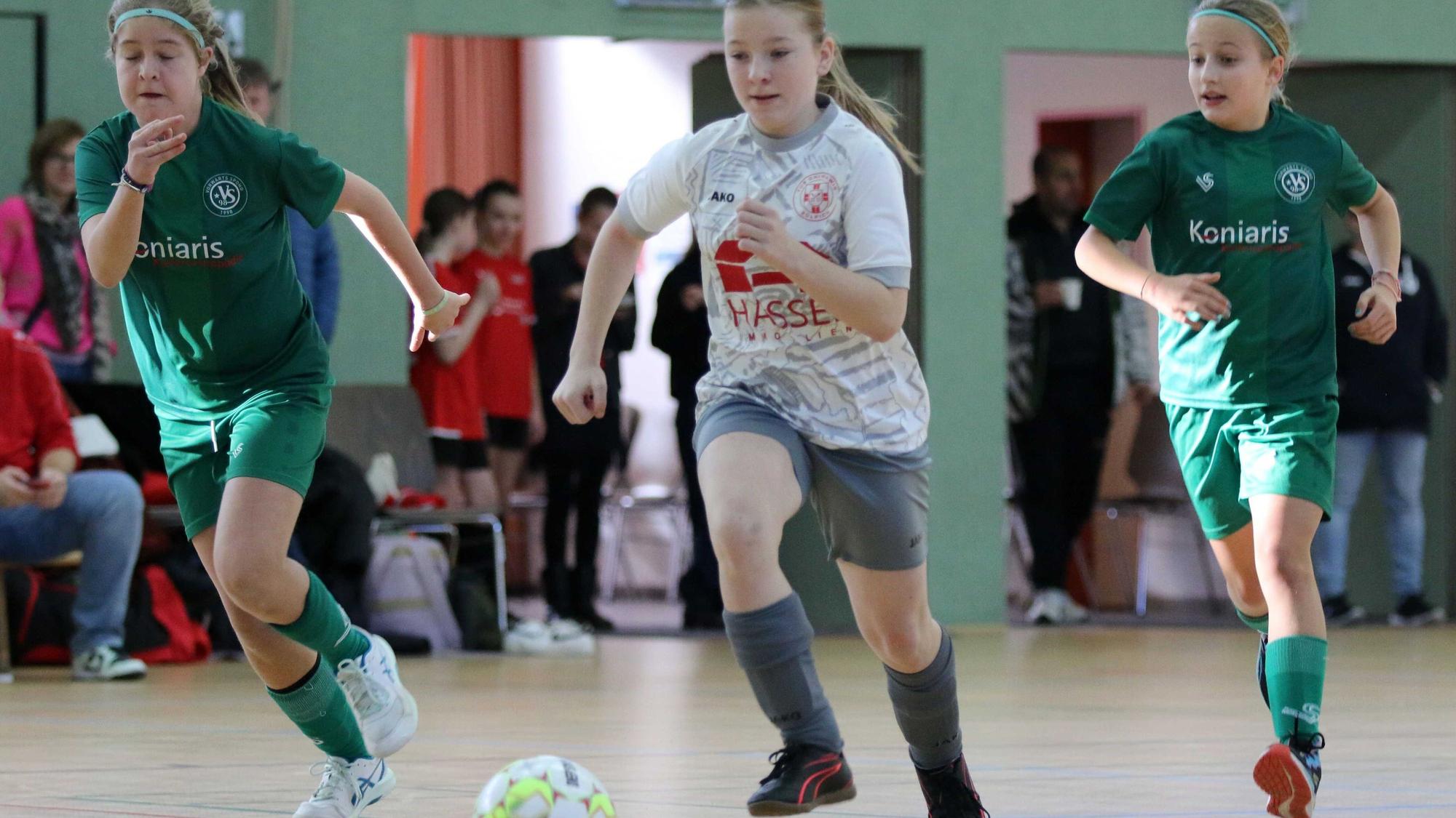 Eine Zülpicher Spielerin führt den Ball und wird von zwei Gegenspielerinnen flankiert.