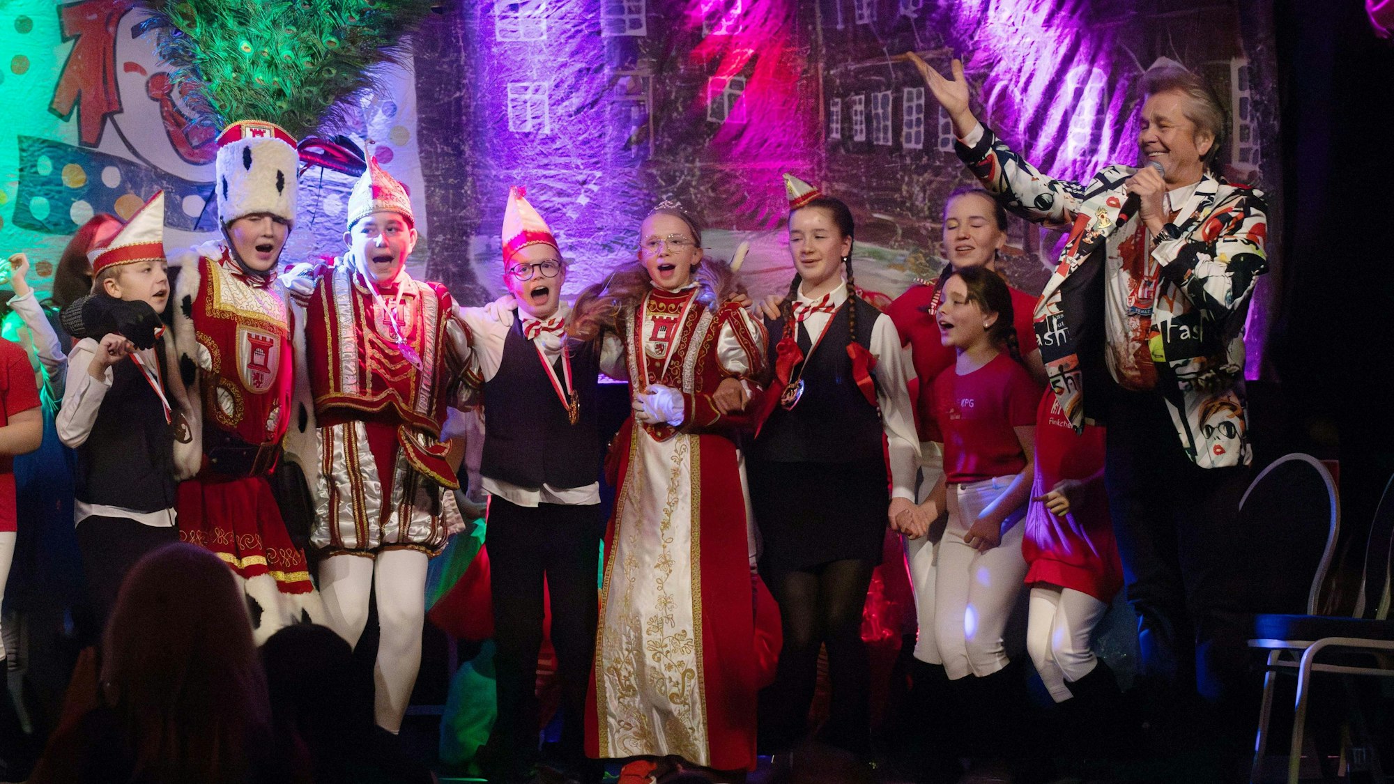 Mega-Fete auf der Bühne im Wahner Eltzhof: Das Porzer Kinderdreigestirn mit seinen Adjutanten und Mister Musik Jürgen Vorrath (r.).