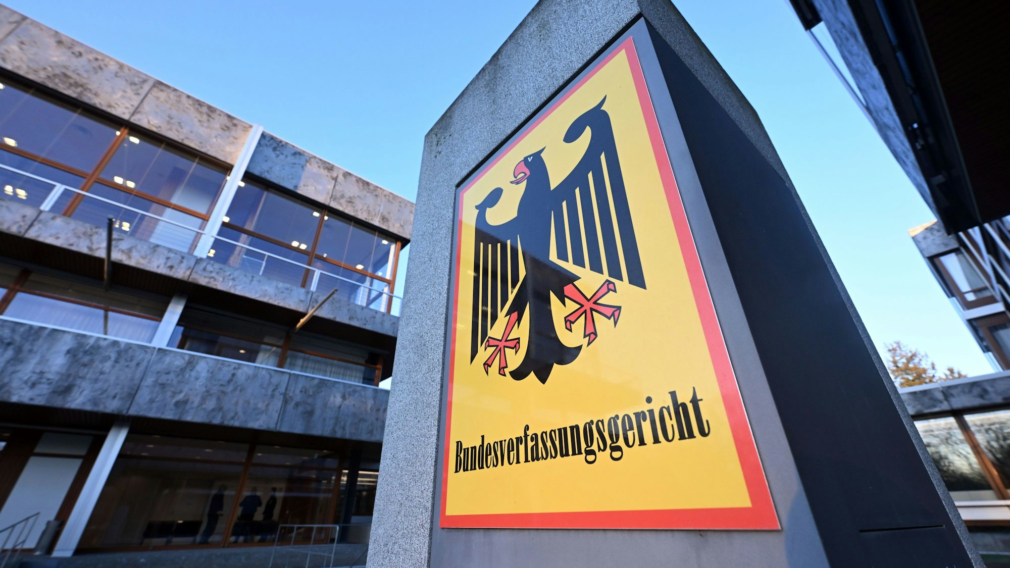 Ein Hinweisschild mit Bundesadler und dem Schriftzug ‚Bundesverfassungsgericht‘ steht vor dem Gerichtsgebäude.