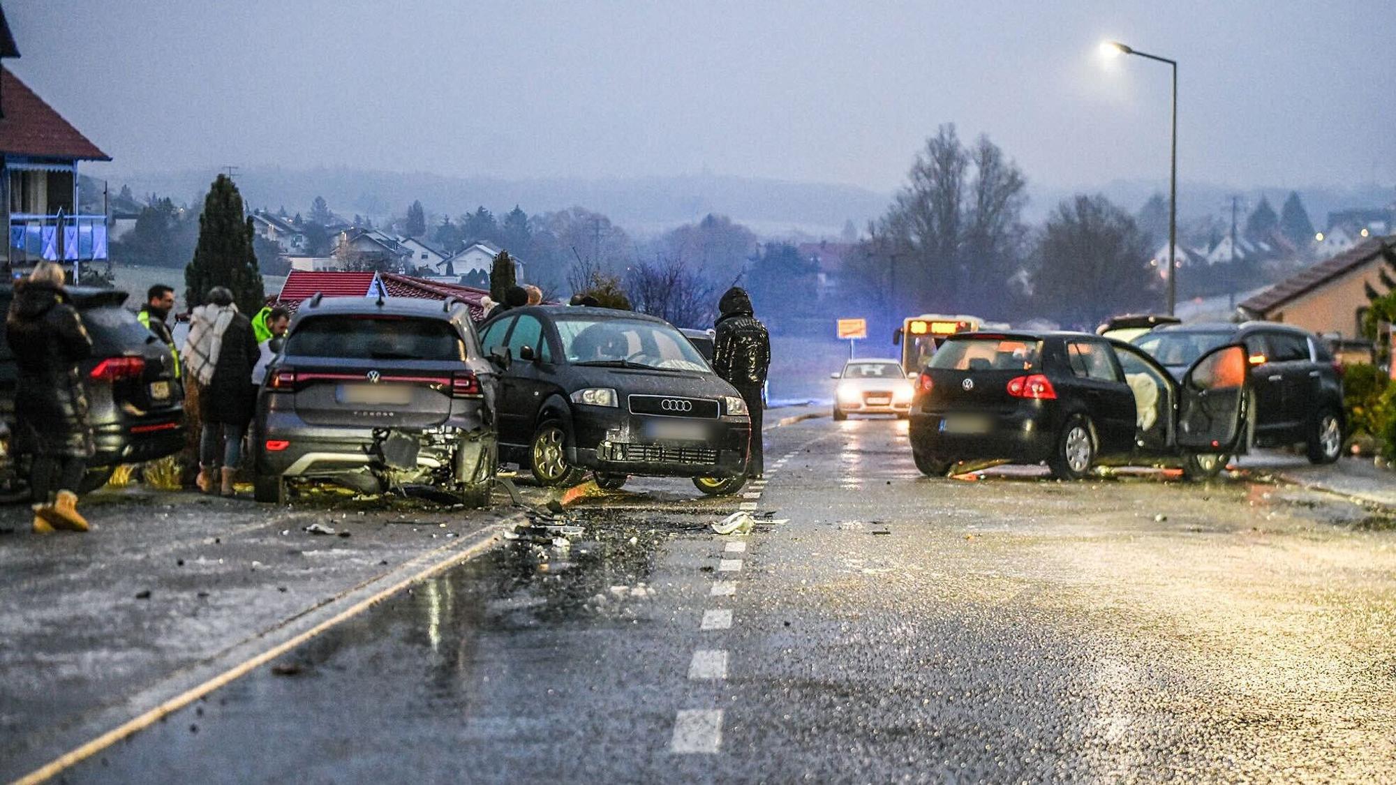 15.01.2025, Baden-Württemberg, Aalen: Nach einem Unfall bei Glatteis mit mehreren Fahrzeugen stehen Helfer und Beteiligte an den Autos auf einer Straße. Auf spiegelglatten Straßen hat die Polizei in Baden-Württemberg am Morgen insgesamt mehr als 100 Unfälle gezählt. Foto: Jason Tschepljakow/dpa - ACHTUNG: Die Kennzeichen wurde(n) aus rechtlichen Gründen gepixelt +++ dpa-Bildfunk +++