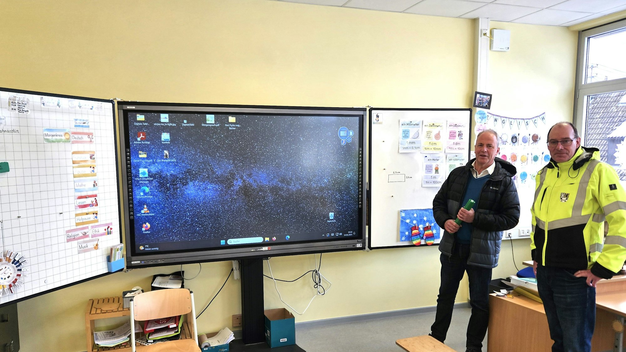 Lothar Schatten und Bürgermeister Hermann-Josef Esser stehen neben einem Smartboard.
