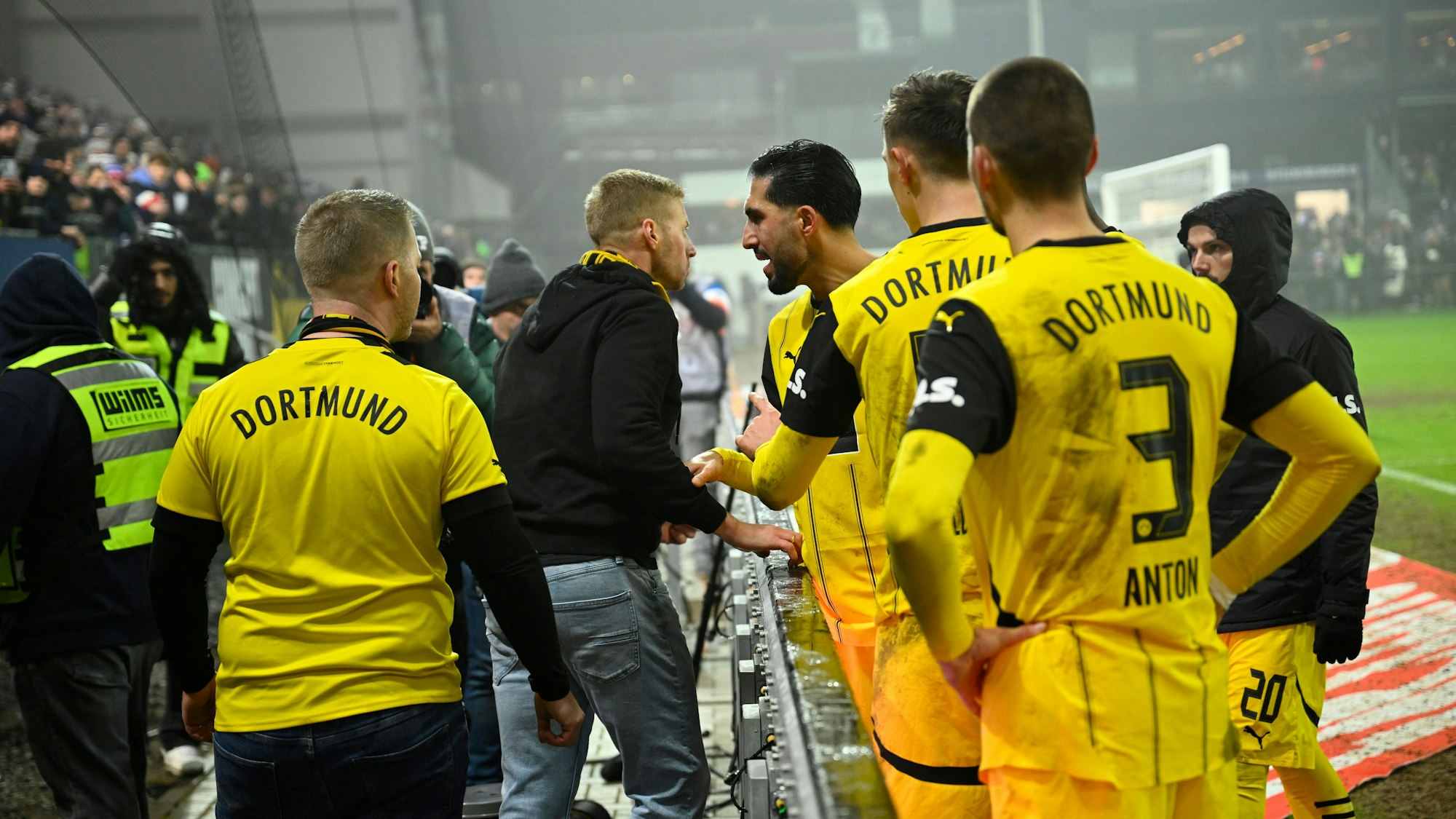 14.01.2025, Schleswig-Holstein, Kiel: Fußball: Bundesliga, Holstein Kiel - Borussia Dortmund, 17. Spieltag, Holstein-Stadion. Spieler Emre Can diskutiert mit einem Dortmund-Fan nach dem 4:2-Sieg am Spielfeldrand. Foto: Gregor Fischer/dpa - WICHTIGER HINWEIS: Gemäß den Vorgaben der DFL Deutsche Fußball Liga bzw. des DFB Deutscher Fußball-Bund ist es untersagt, in dem Stadion und/oder vom Spiel angefertigte Fotoaufnahmen in Form von Sequenzbildern und/oder videoähnlichen Fotostrecken zu verwerten bzw. verwerten zu lassen. +++ dpa-Bildfunk +++