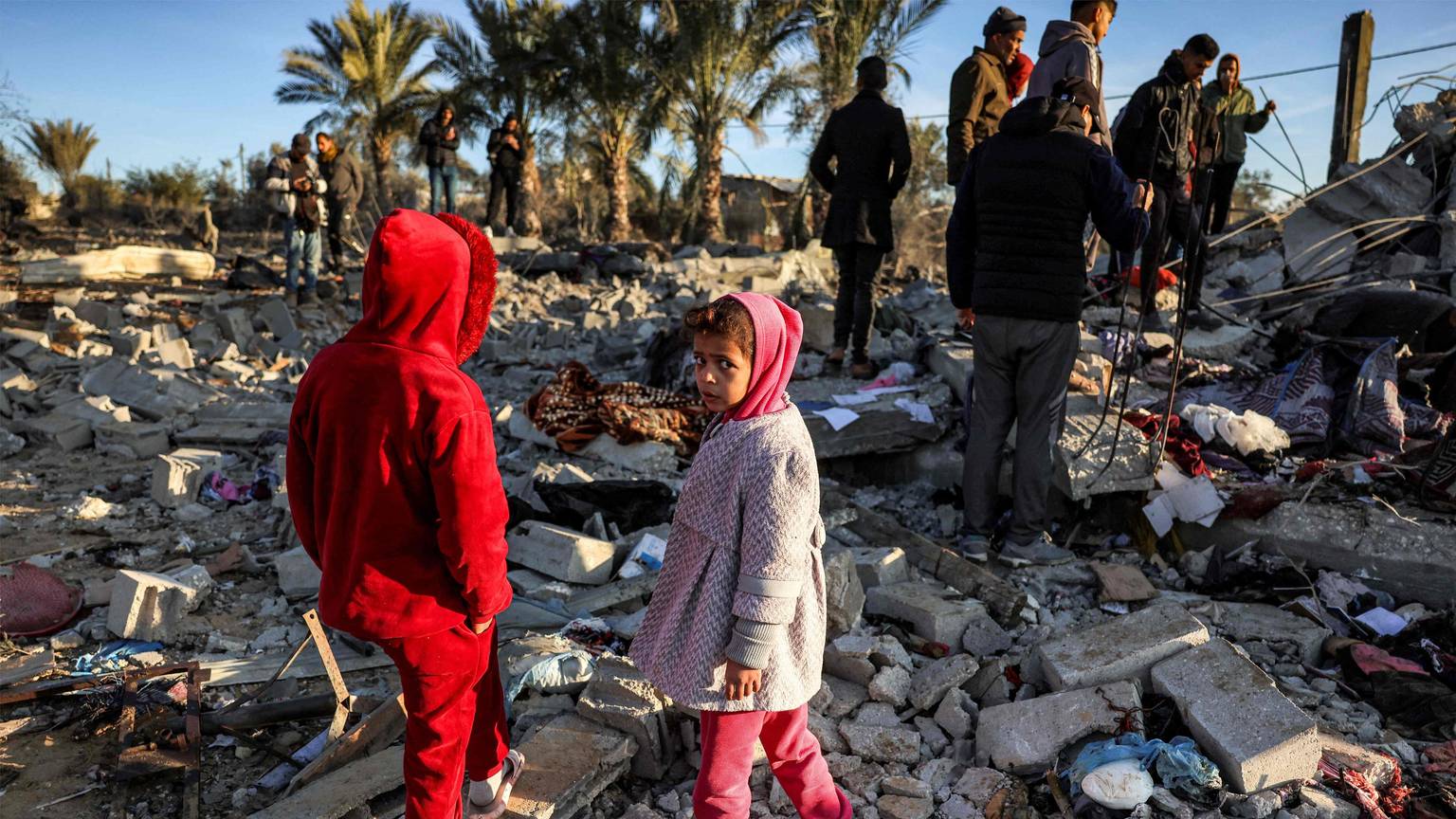 Children stand by rubble at a site that was hit by Israeli bombardment east of Khan Yunis in the southern Gaza Strip on January 14, 2025 amid the ongoing war in the Palestinian territory between Israel and Hamas. (Photo by BASHAR TALEB / AFP)
