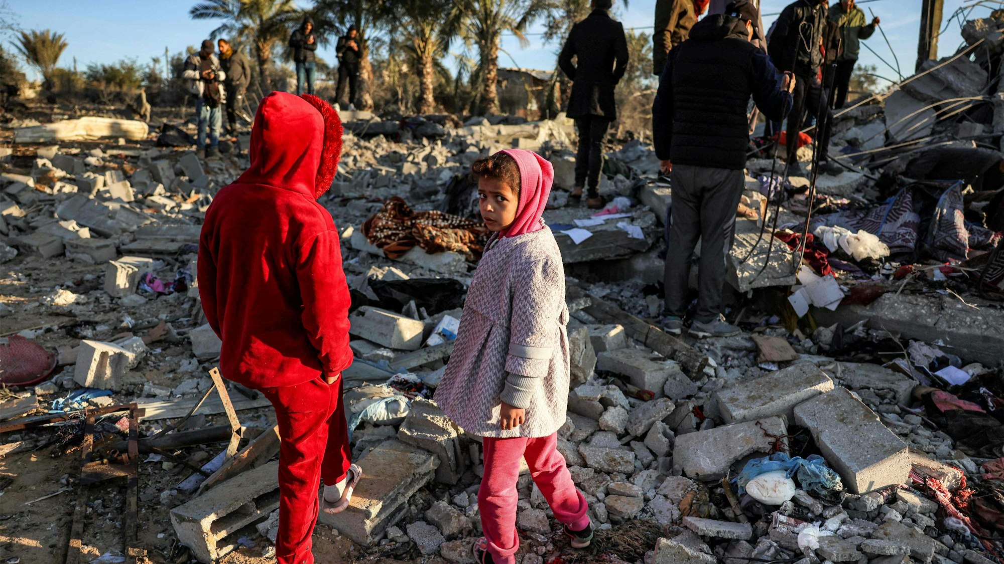 Children stand by rubble at a site that was hit by Israeli bombardment east of Khan Yunis in the southern Gaza Strip on January 14, 2025 amid the ongoing war in the Palestinian territory between Israel and Hamas. (Photo by BASHAR TALEB / AFP)