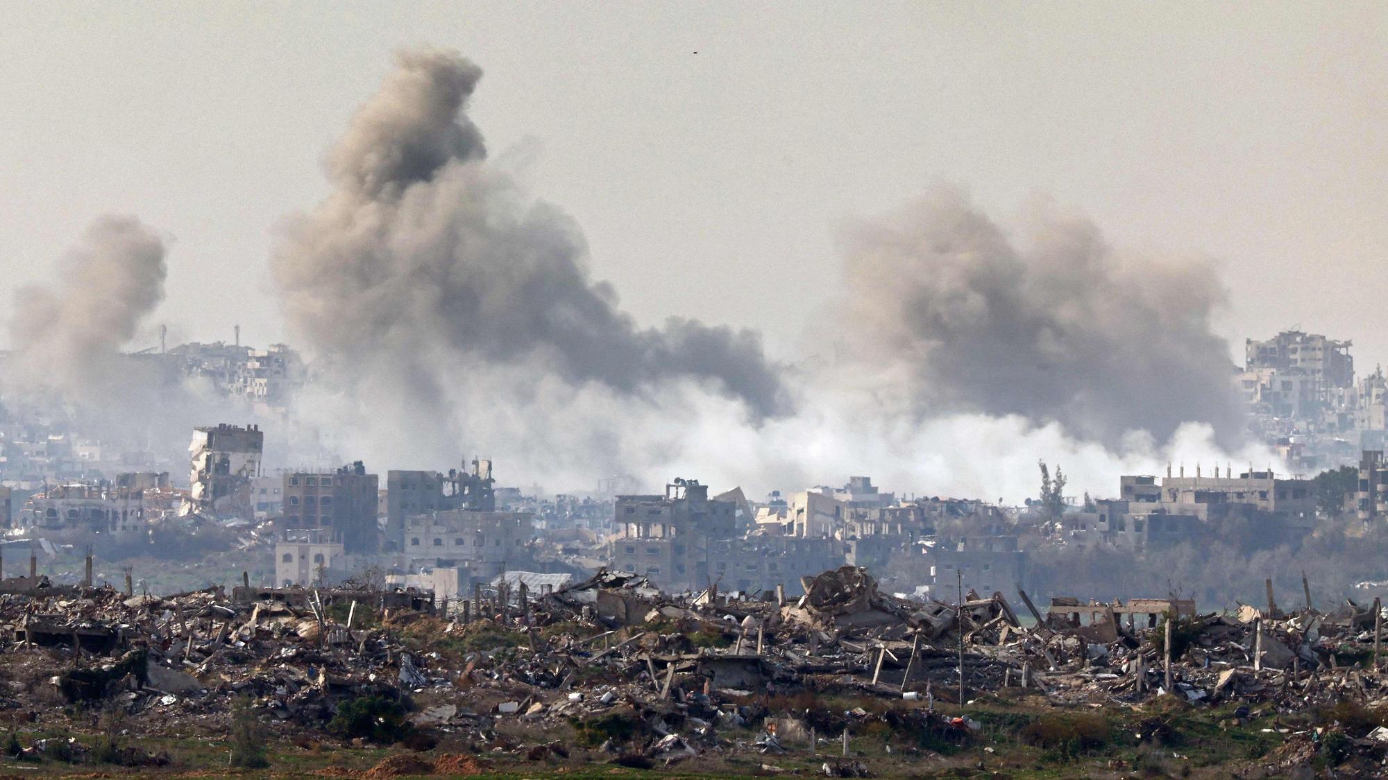 This picture taken from the Israeli side of the border with the Gaza Strip shows smoke plumes rising from explosions above destroyed buildings in the northern Gaza Strip on January 14, 2025, amid the ongoing war between Israel and Hamas. (Photo by Jack GUEZ / AFP)