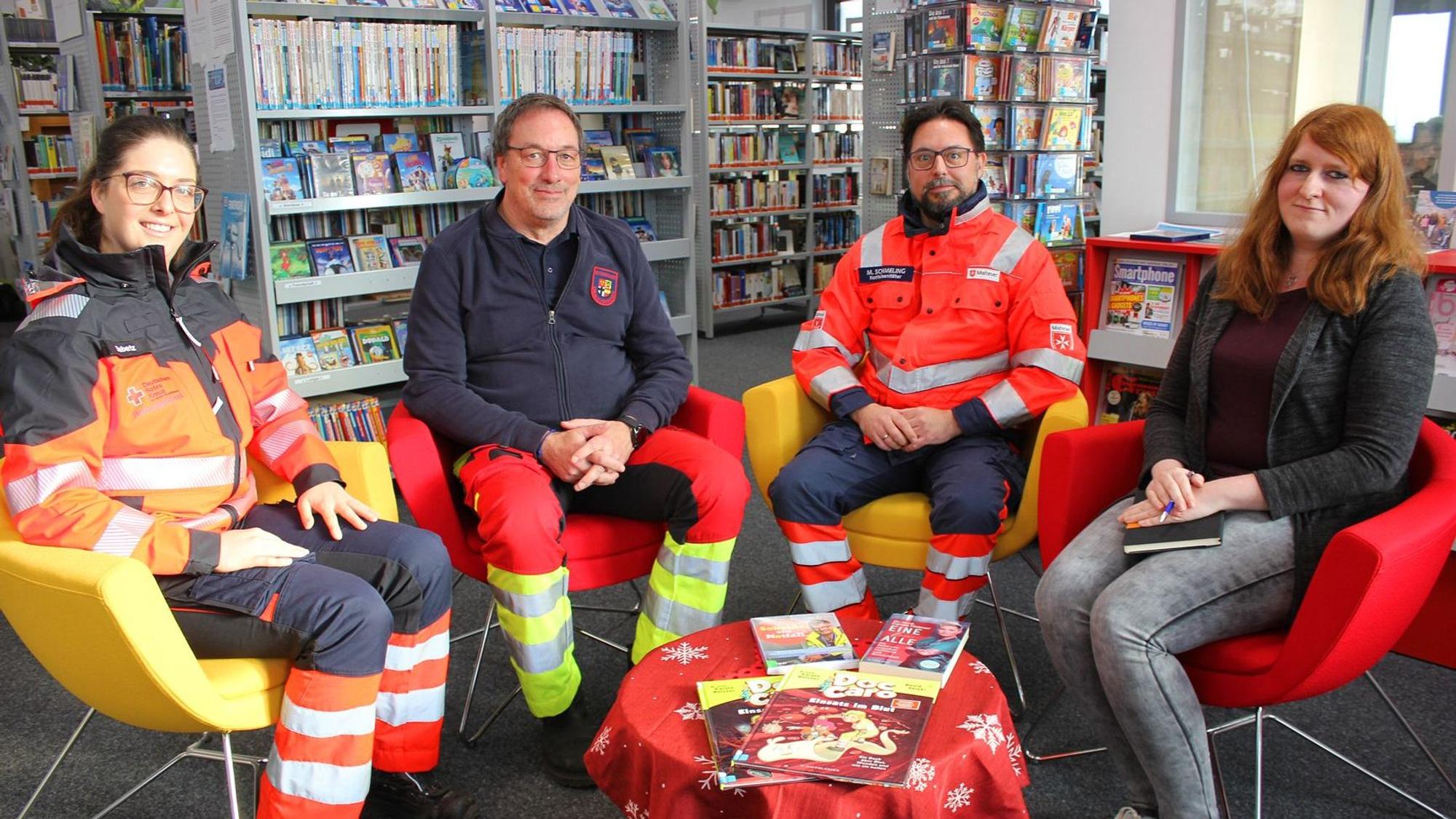 Vanessa Siebertz, Rainer Brück, Michael Schmeling und Michelle Wagner sitzen auf Stühlen in der Gemeinde-Bibliothek.