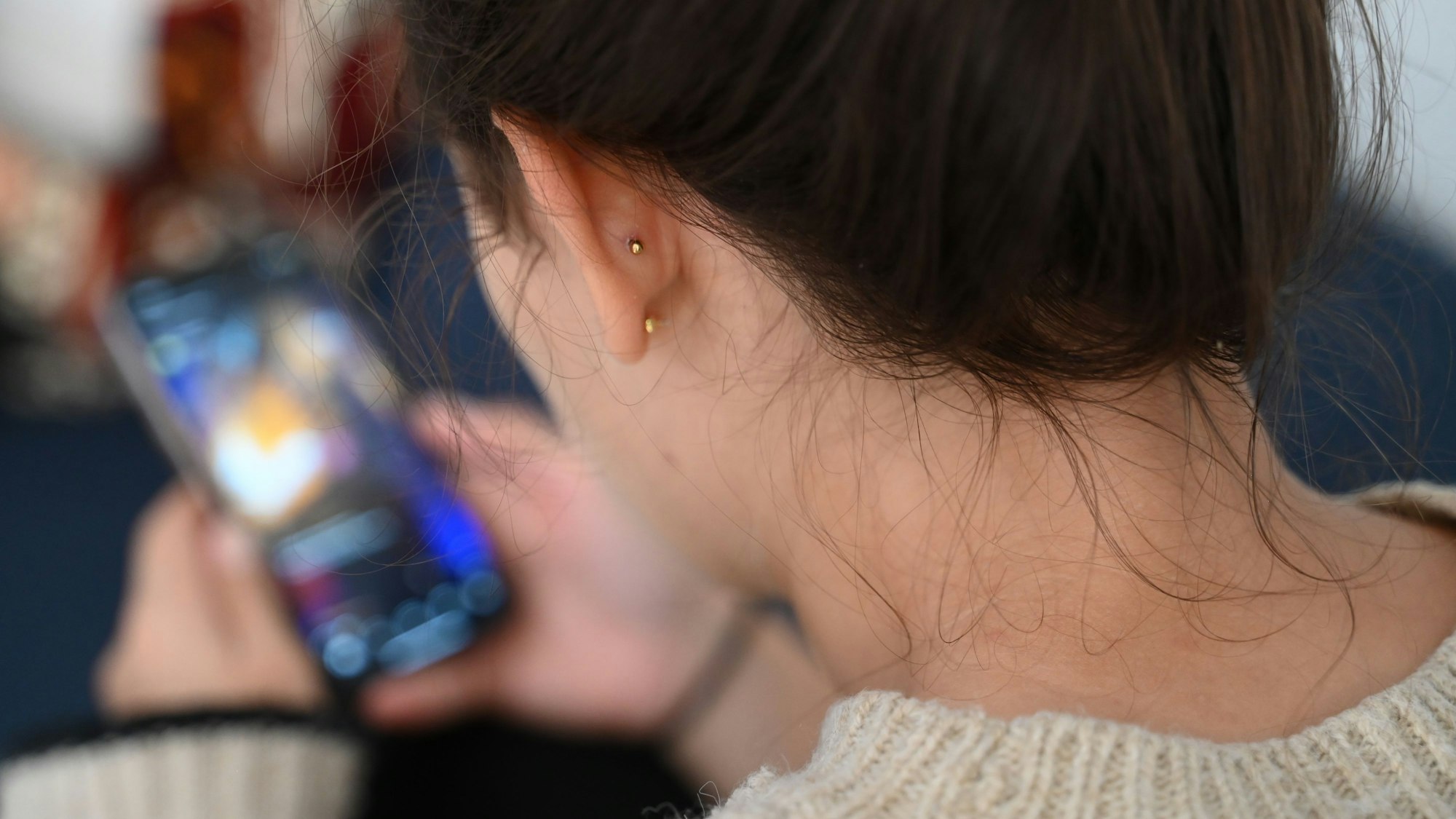 Frau hat ein Handy in der Hand und schaut drauf.