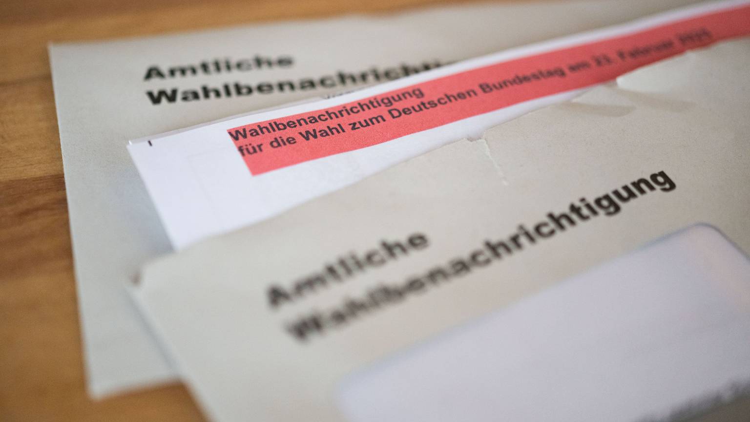 Amtliche Wahlbenachrichtigungen für die Wahl zum Deutschen Bundestag am 23. Februar 2025 liegen auf einem Tisch.