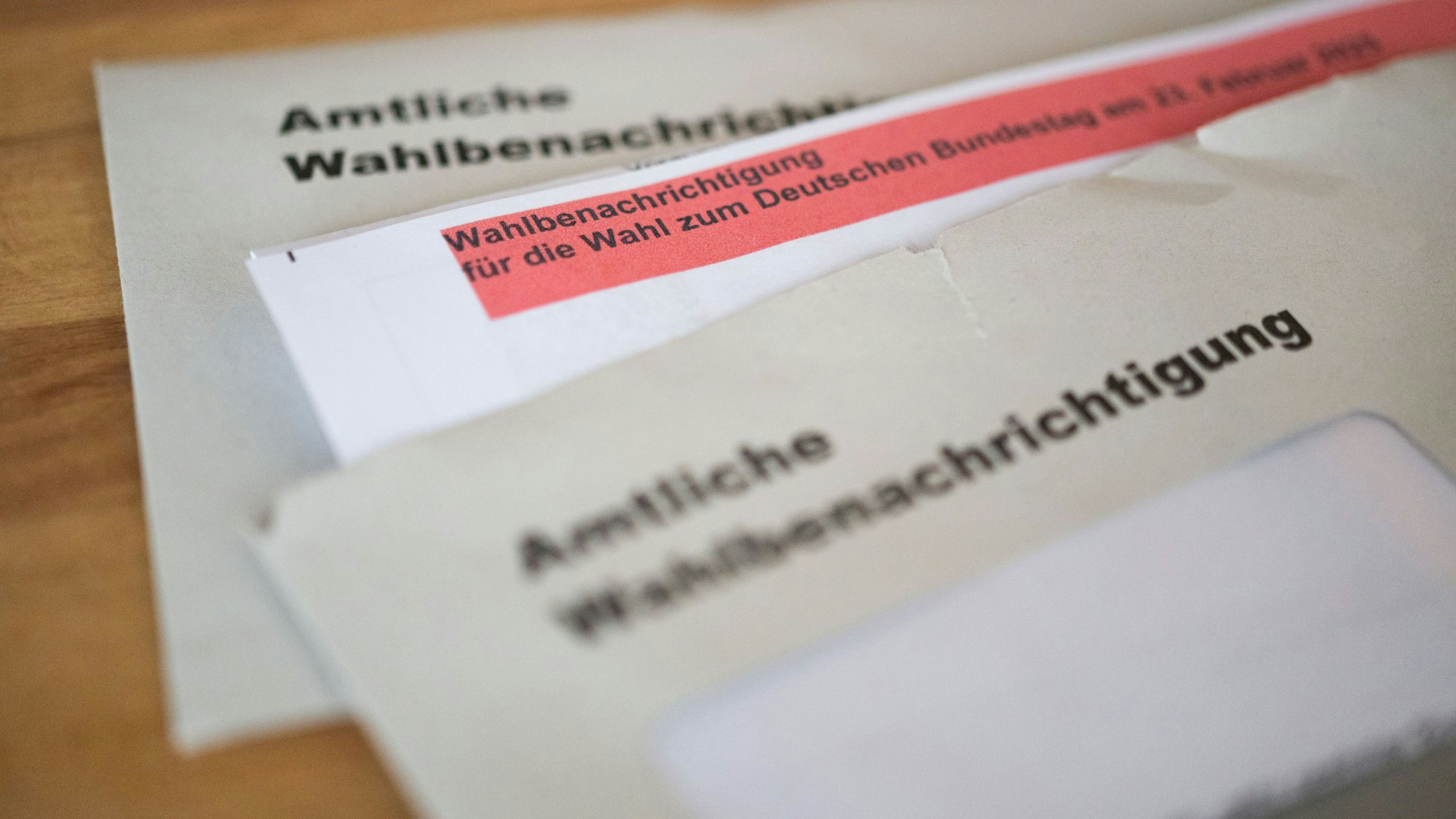 Amtliche Wahlbenachrichtigungen für die Wahl zum Deutschen Bundestag am 23. Februar 2025 liegen auf einem Tisch.