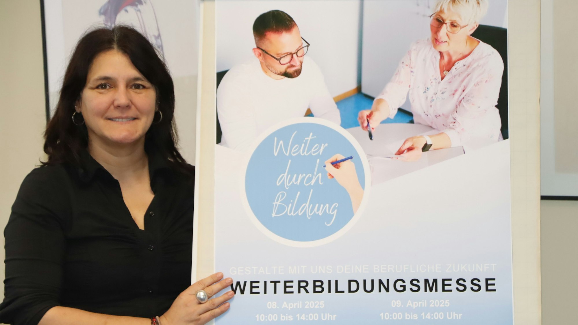 Eine Frau steht neben einem Plakat.