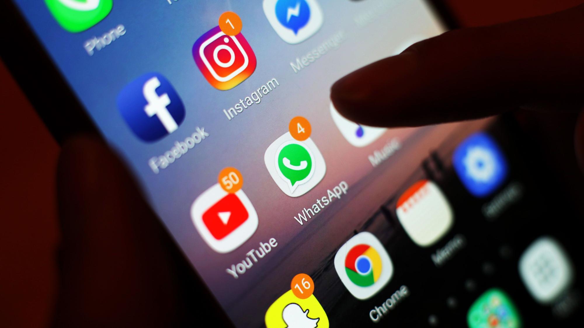 Ein Smartphone-Display mit Symbolen von Social-Media-Apps, darunter Facebook, Instagram, YouTube und WhatsApp.