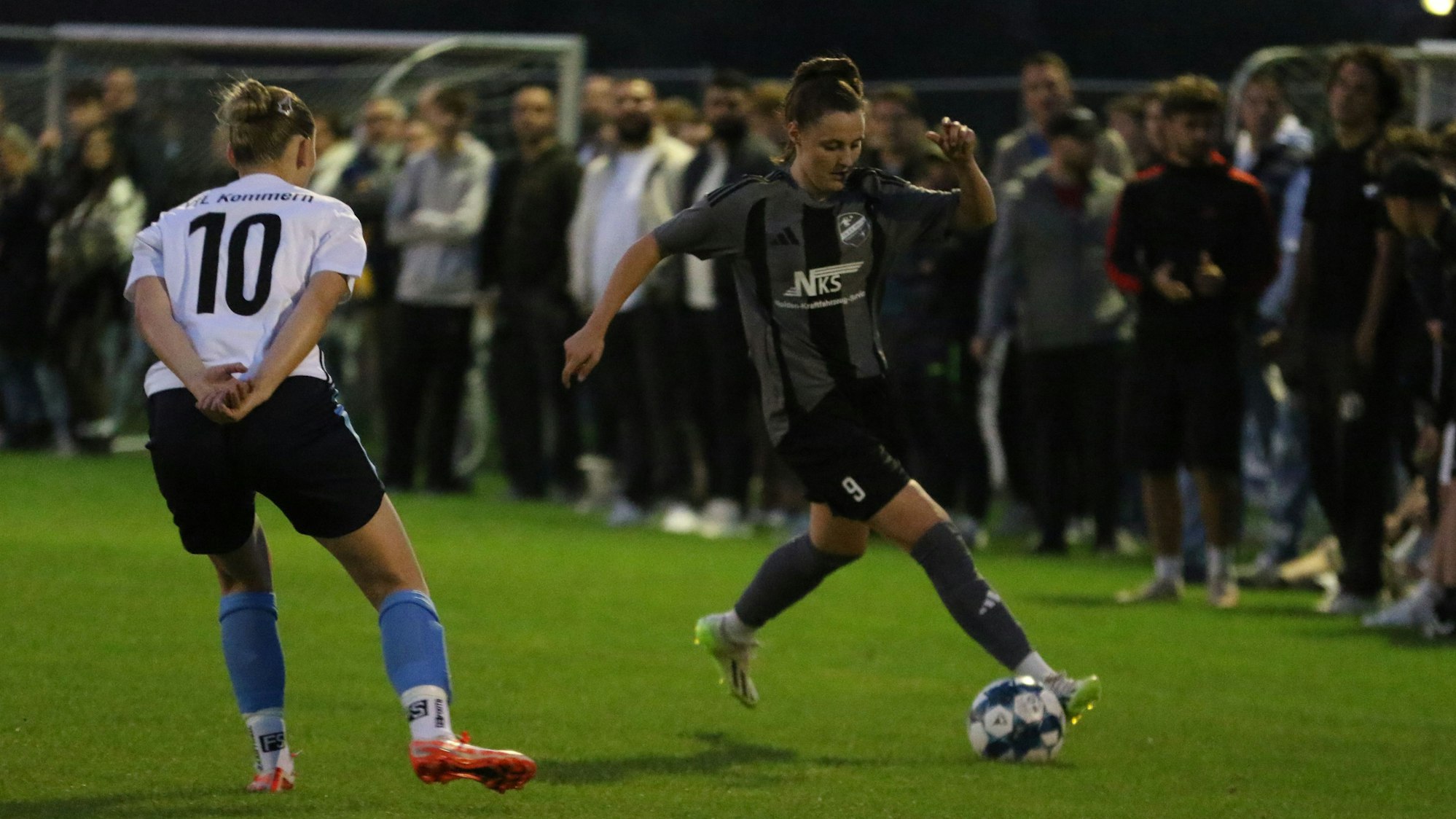 Laura Barber dribbelt um Nele Schommers herum. Im Hintergrund stehen viele Zuschauer.