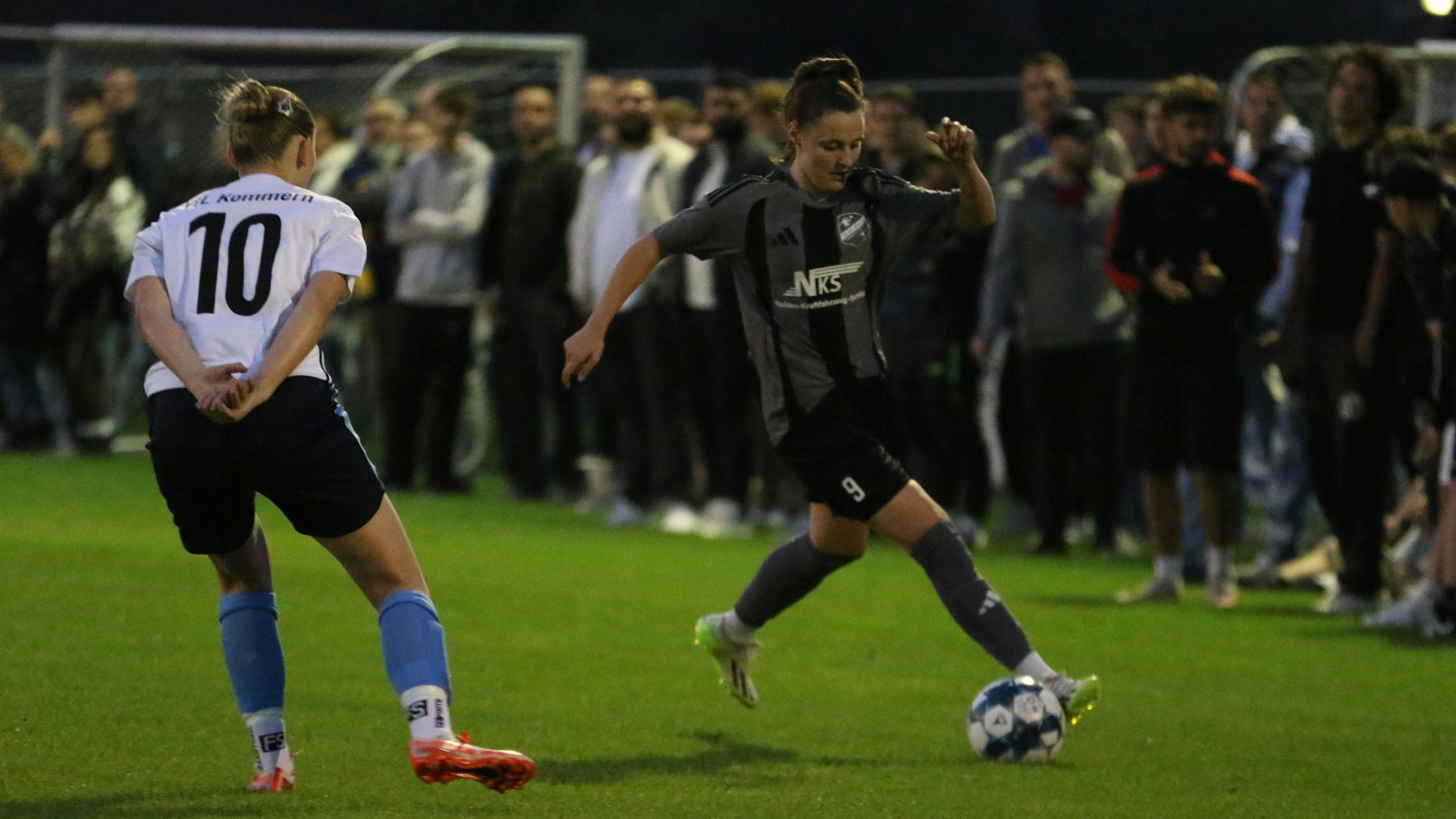 Laura Barber dribbelt um Nele Schommers herum. Im Hintergrund stehen viele Zuschauer.