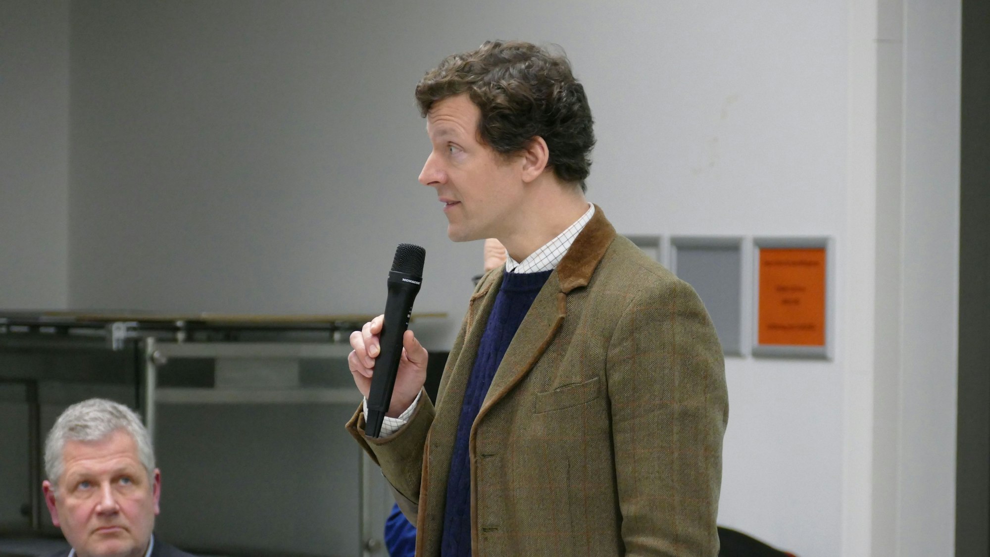 Ein Mann spricht in ein Mikrofon.