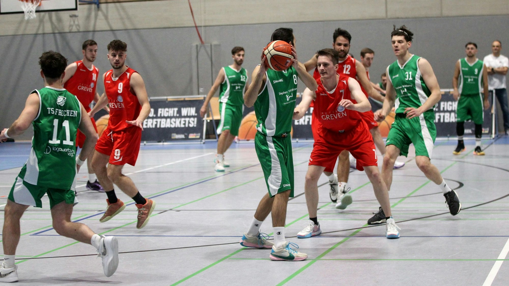 Ein Frechener Spieler hält den Ball und schirmt ihn vor einem Gegenspieler aus Bad Münstereifel ab.