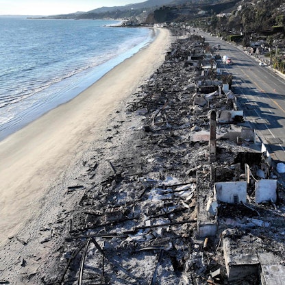 Eine heruntergebrannte Häuserreihe am Strand, aus der Luft gesehen.